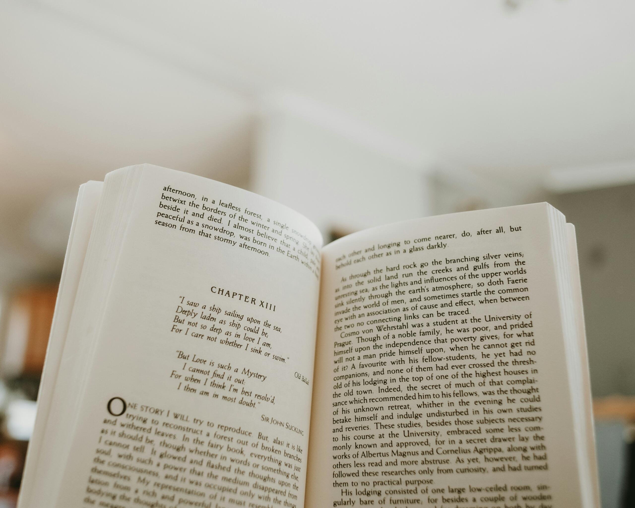 Persona sosteniendo un libro abierto con una página de texto visible.