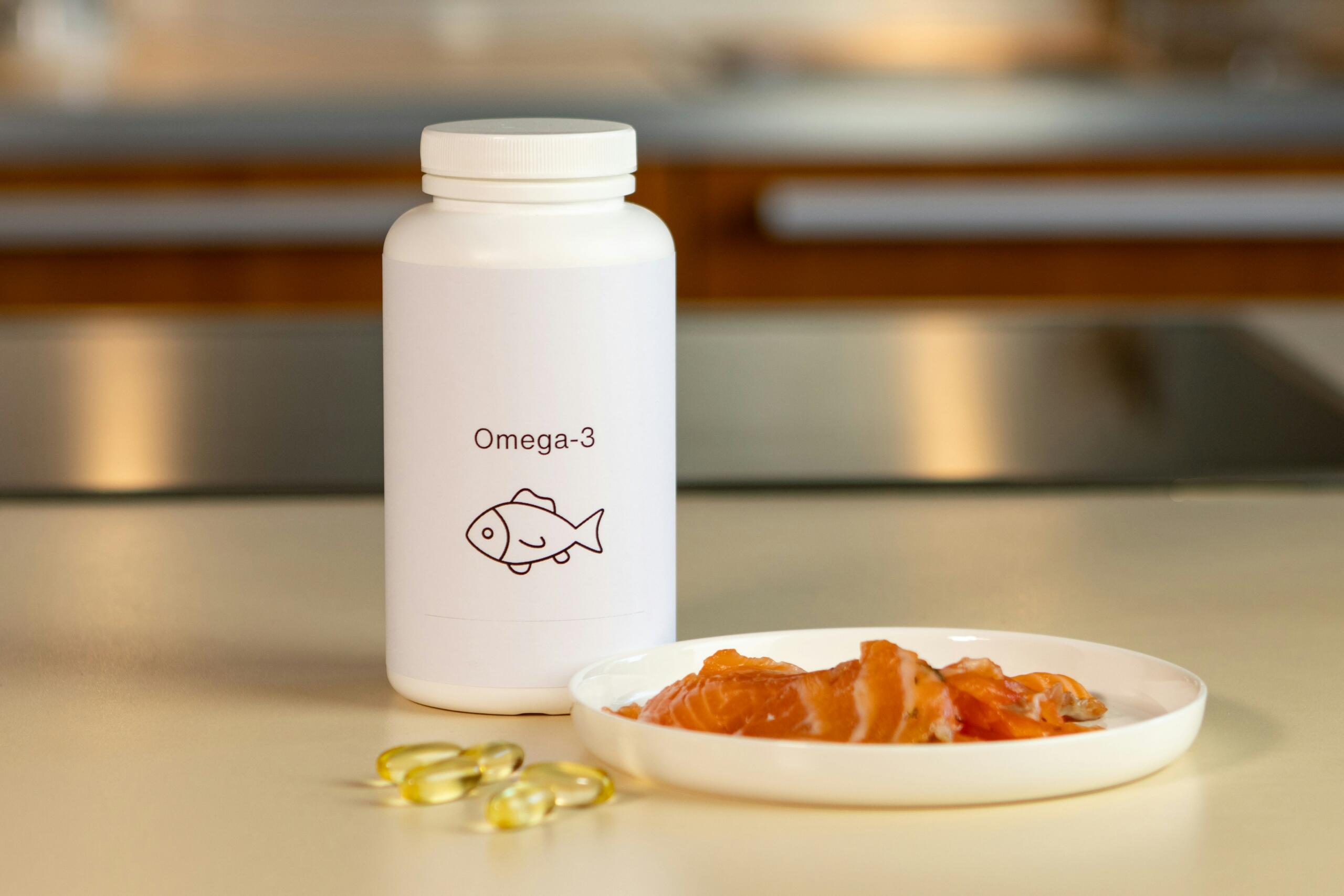 Un frasco blanco con la etiqueta «Omega-3» y un dibujo de un pez, junto a un plato de lonchas de salmón y cápsulas de omega-3 sobre una encimera.