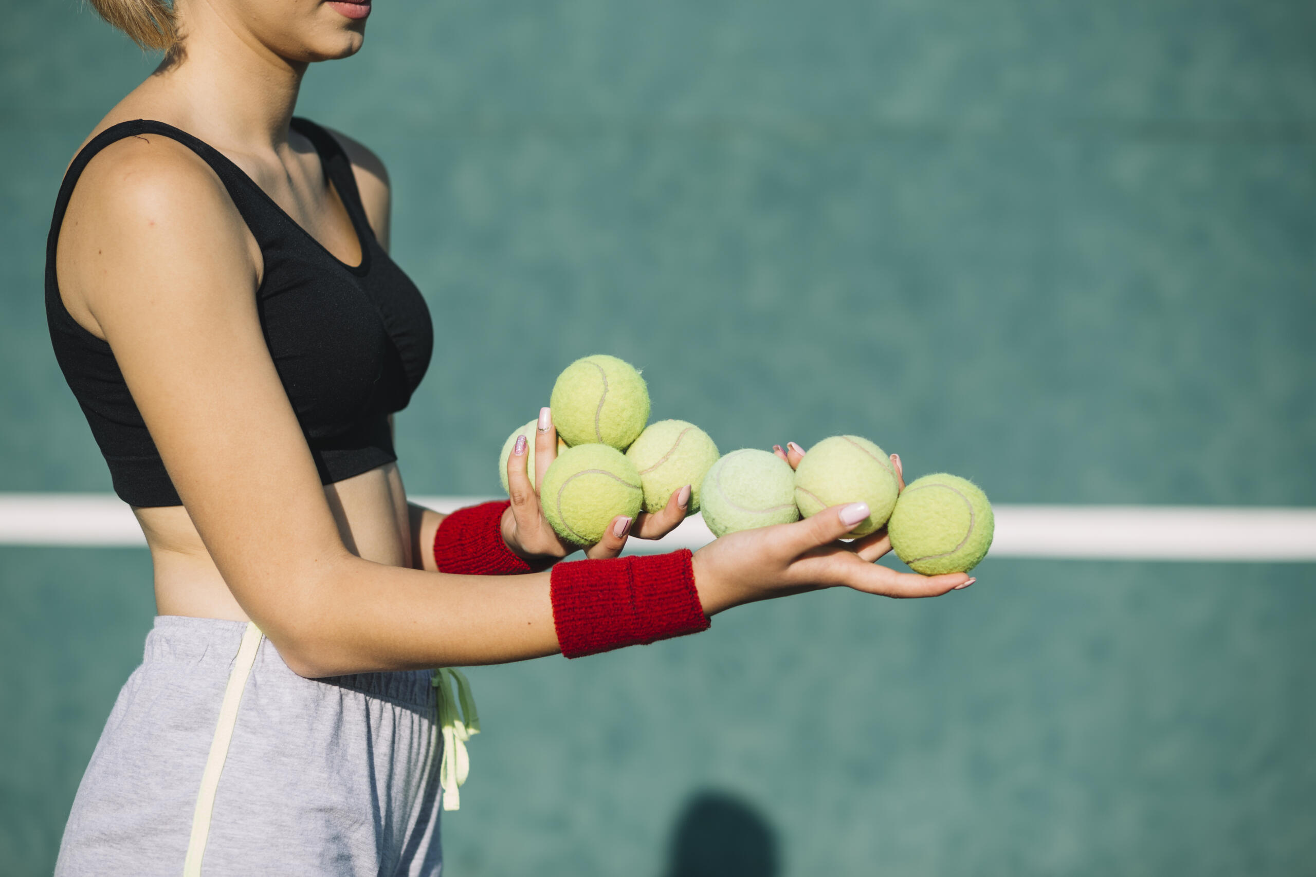 Mujer sosteniendo pelotas de tenis