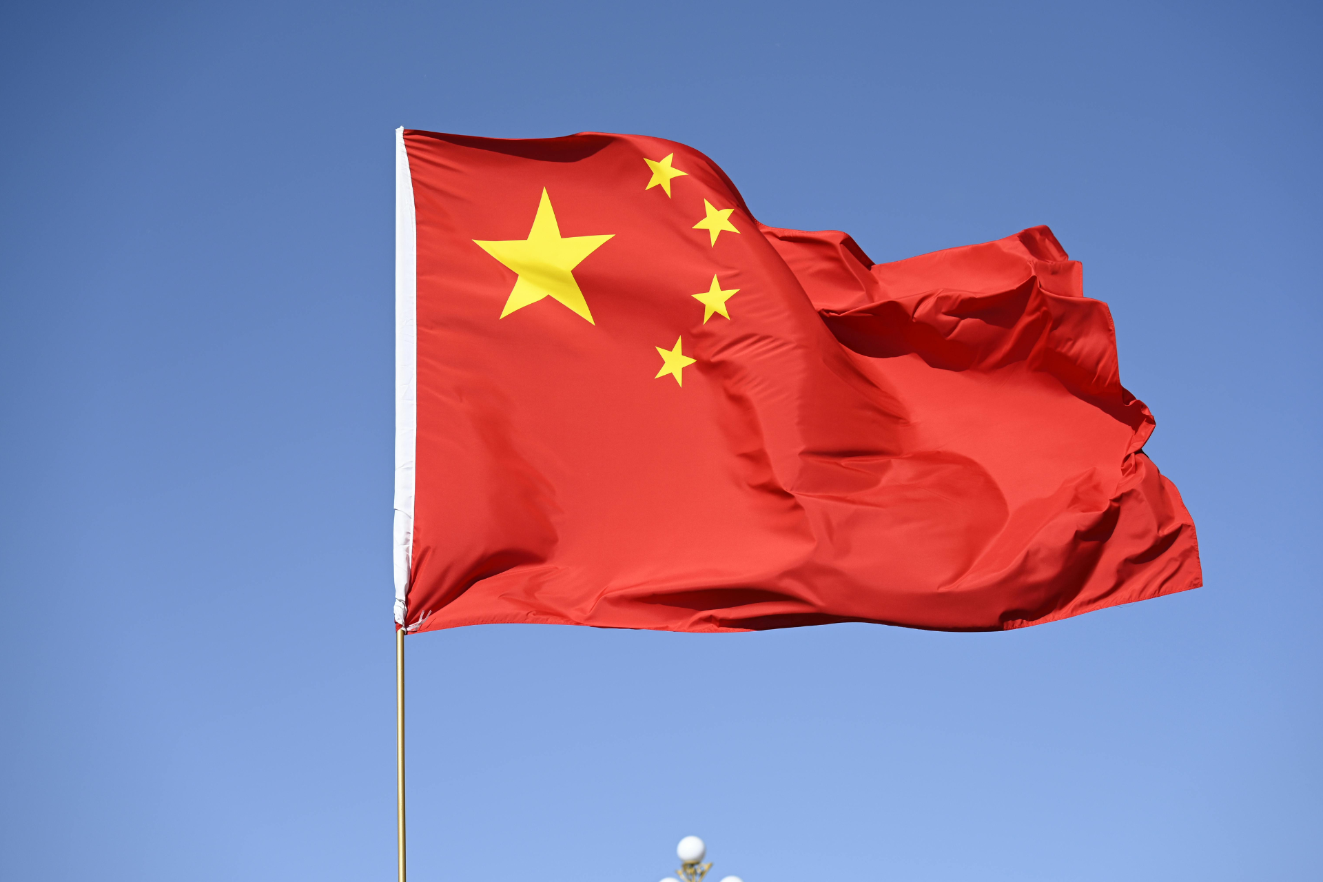Bandera de China con un fondo rojo y cinco estrellas amarillas en la parte superior izquierda.
