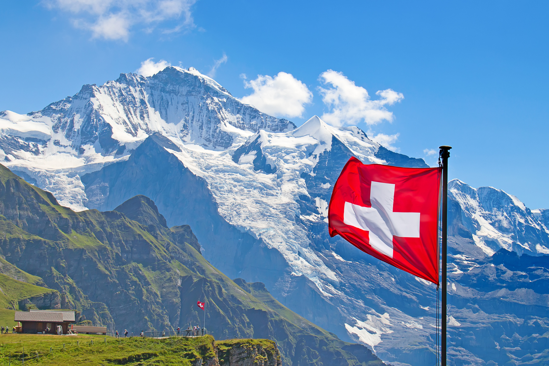 Bandera de Suiza con un fondo rojo y una cruz blanca en el centro.