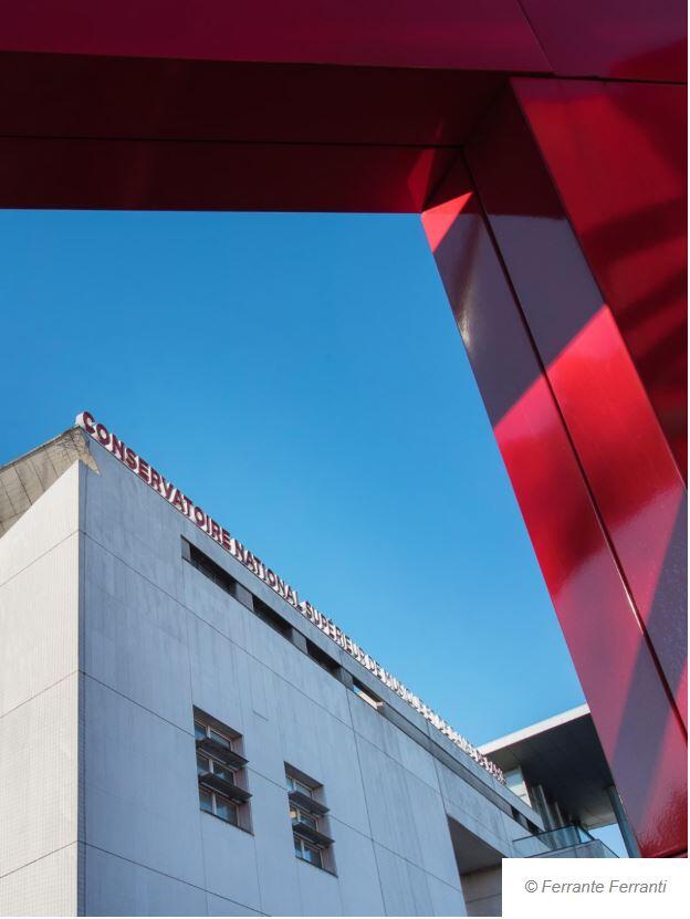 Edificio moderno del Conservatorio con el letrero «Conservatoire National Supérieur». La fachada blanca contrasta con el cielo azul y el marco rojo angular.