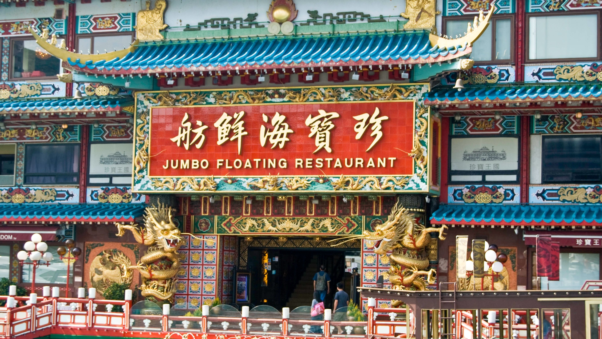 Entrada al lujoso restaurante flotante «Jumbo», con detalles arquitectónicos tradicionales chinos y esculturas de dragones dorados.