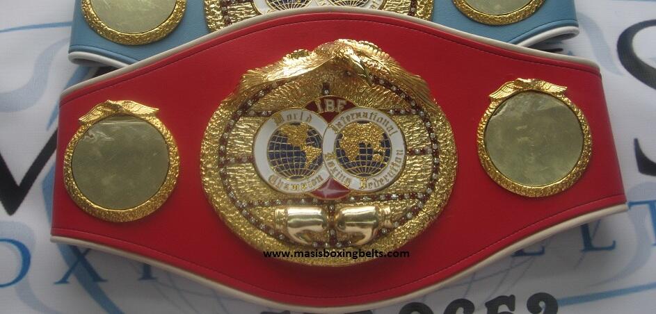 Cinturón de campeón de boxeo con placas doradas, cuero rojo, dos águilas doradas y motivos de un globo terráqueo con la inscripción «World Boxing Federation».