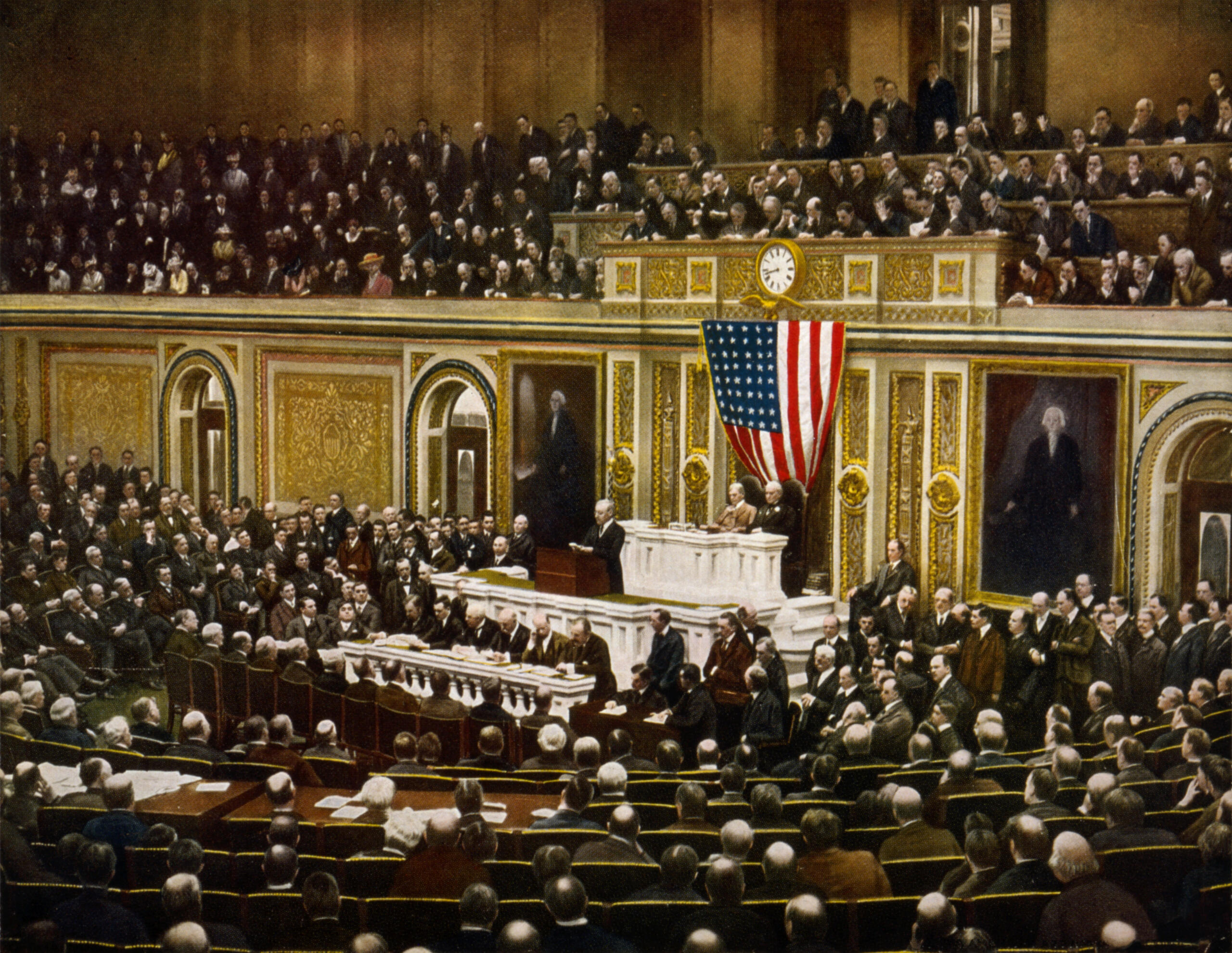 Escena histórica en el Capitolio de EE. UU., en la que el presidente se dirige a una sesión conjunta repleta de gente bajo una gran bandera estadounidense.