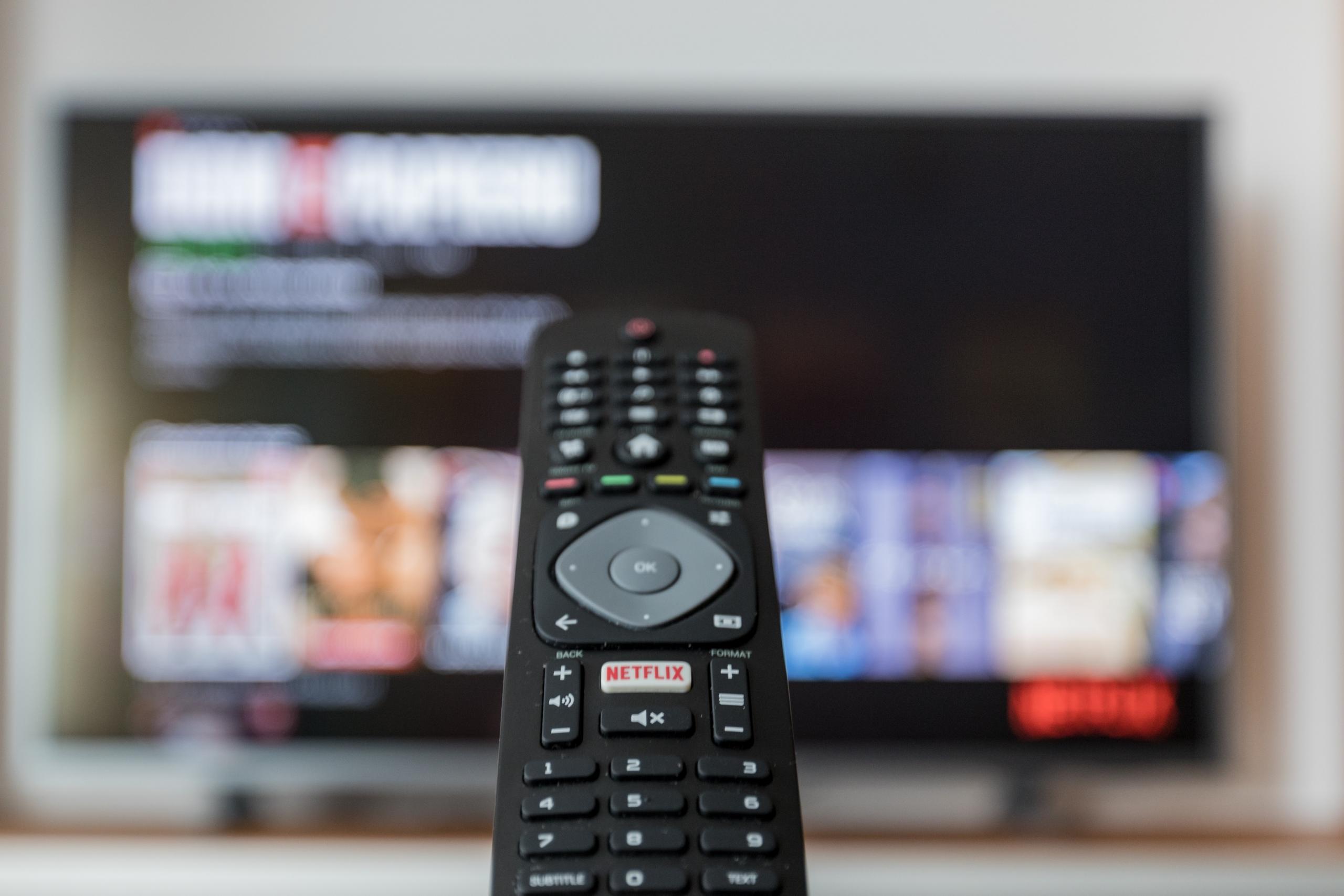 Kaukosäädin ja TV, jossa on Netflix auki