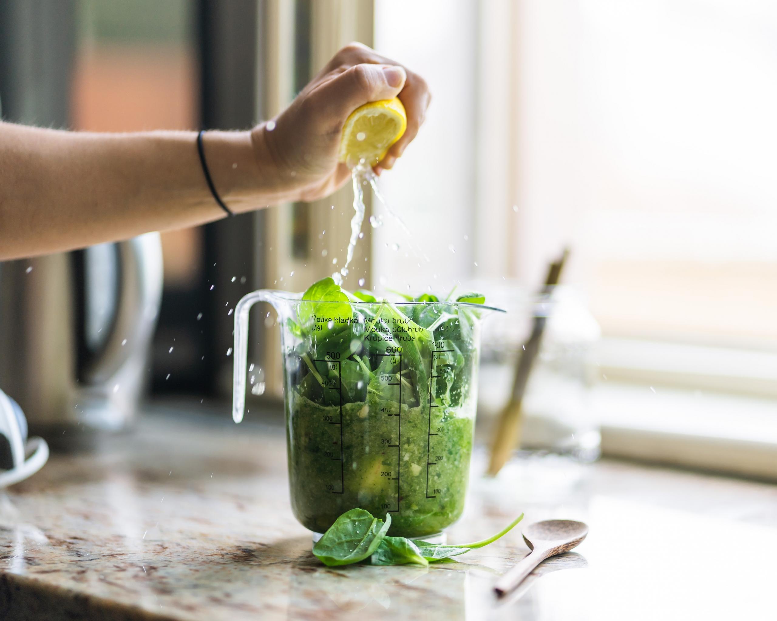 Henkilö tekemässä vihersmoothieta