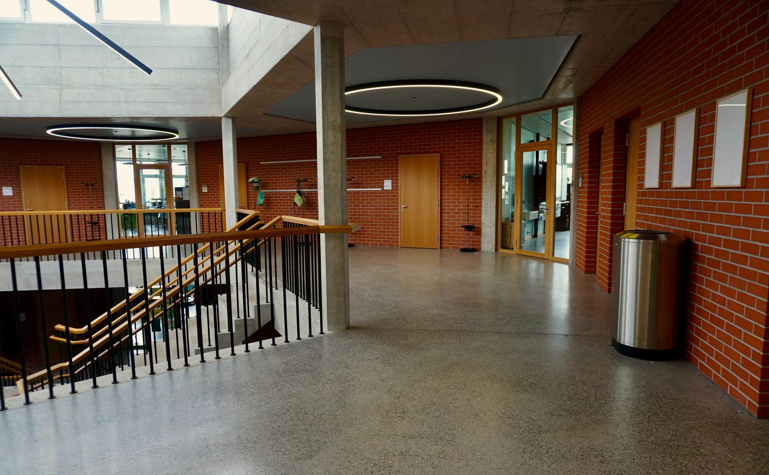 Oppilaitoksen yläaula, jossa punaiset tiiliseinät.