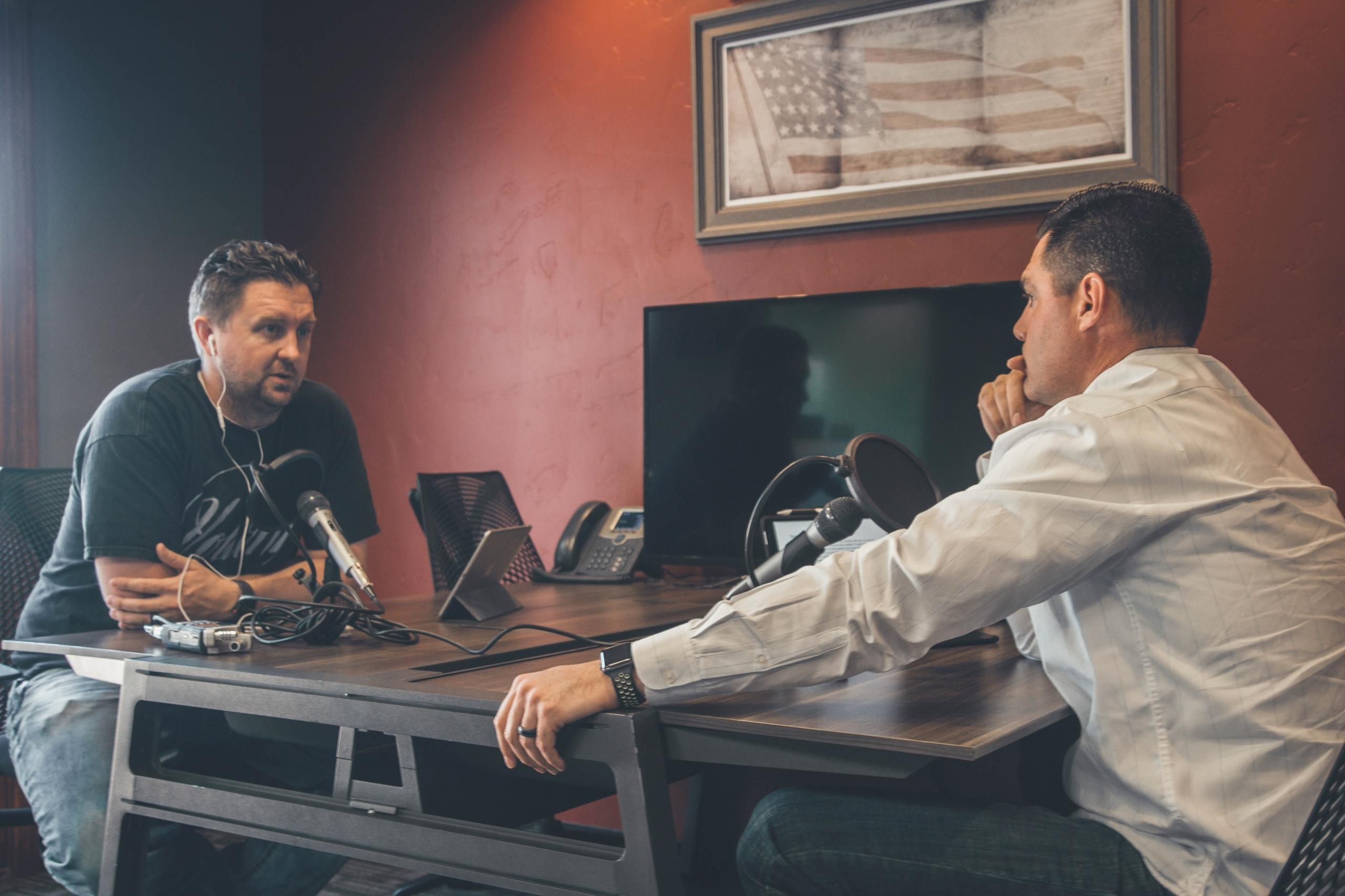 Kaksi miestä nauhoittaa podcastia.