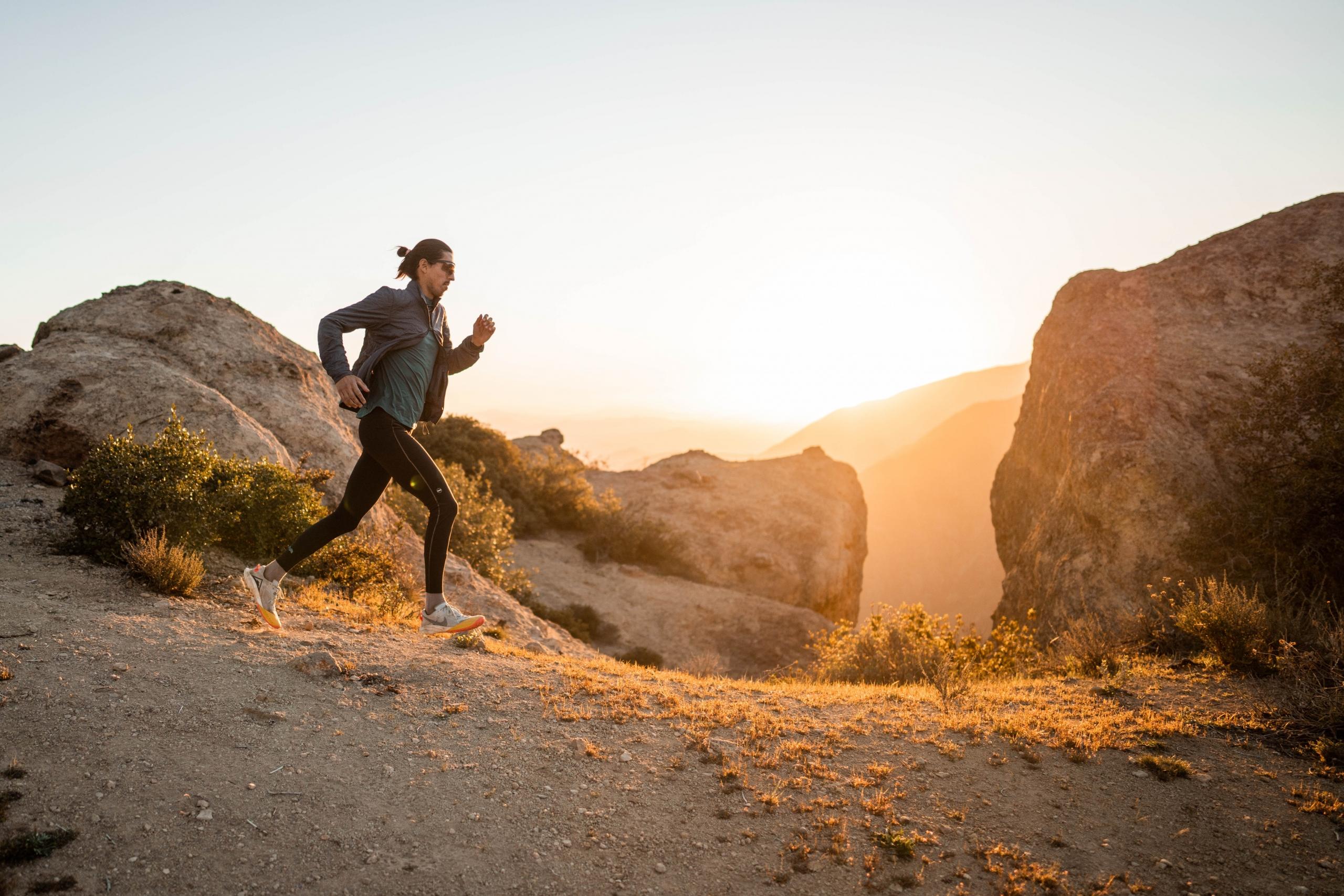 Mies juoksemassa auringon paisteessa.