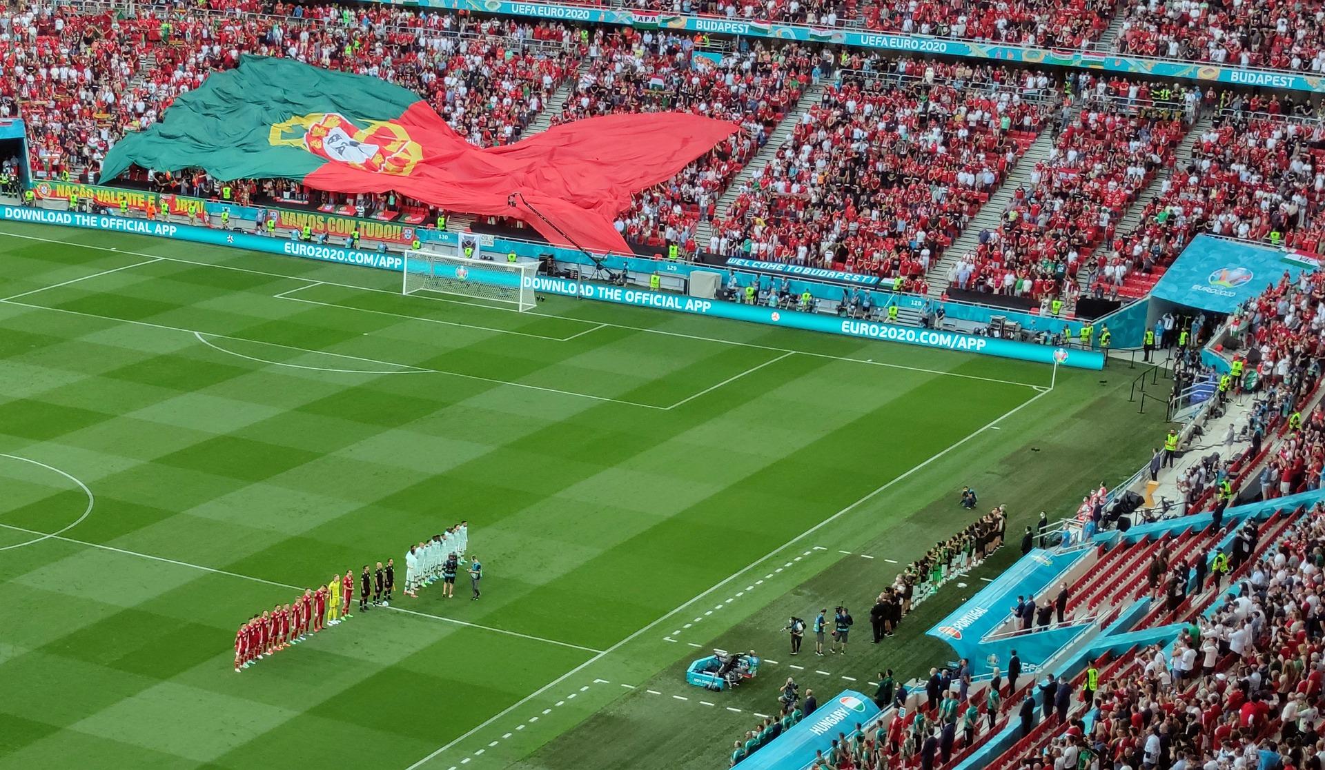 Alkamaisillaan oleva jalkapallo-ottelu stadionilla, jonka katsomossa suuri Portugalin lippu yleisön kannattelemana