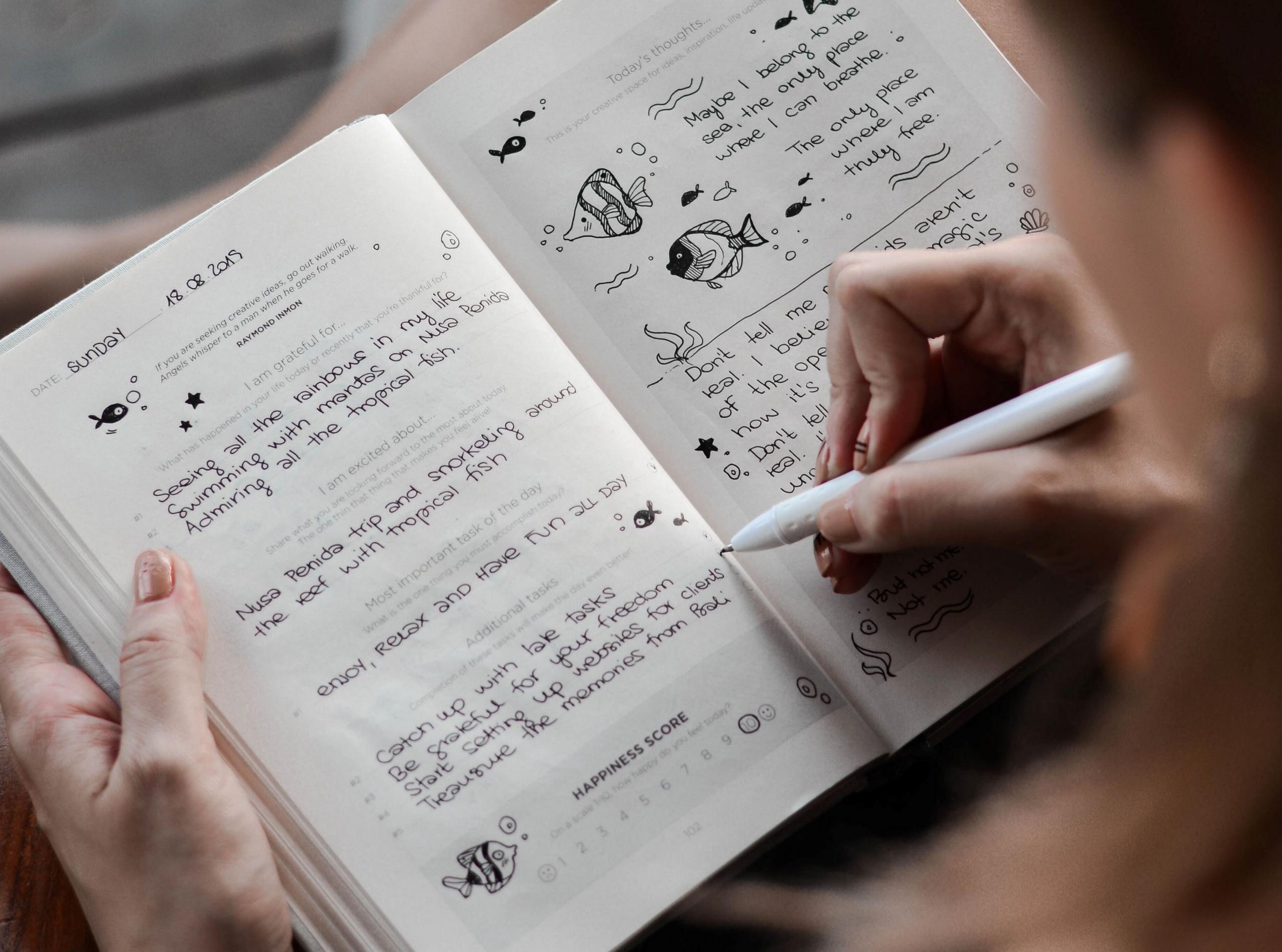 Henkilö kirjoittamassa kirjan sivulle