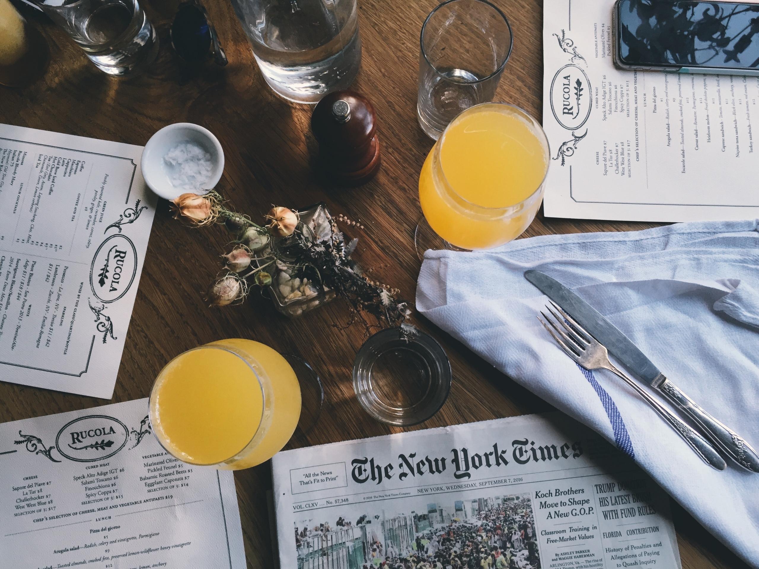 The New York Times -lehti sekä ruokailutarvikkeita pöydällä