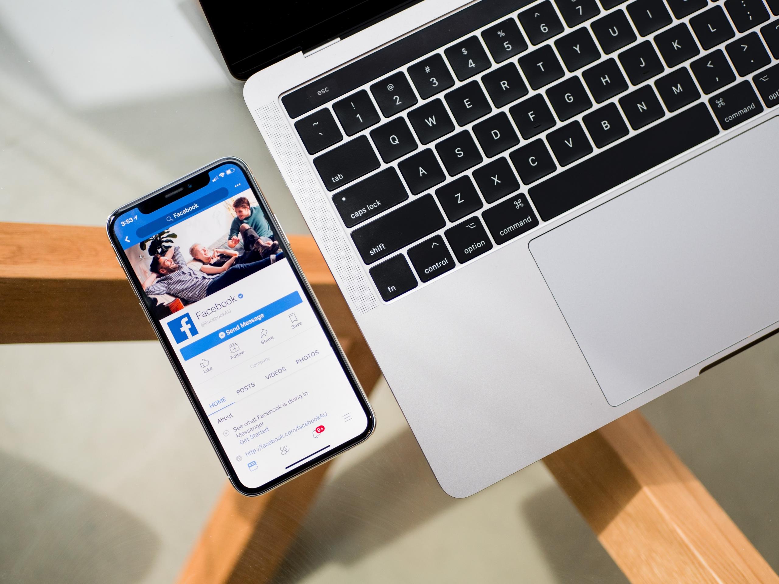 Puhelin, jossa Facebook-sovellus avattuna, sekä kannettava