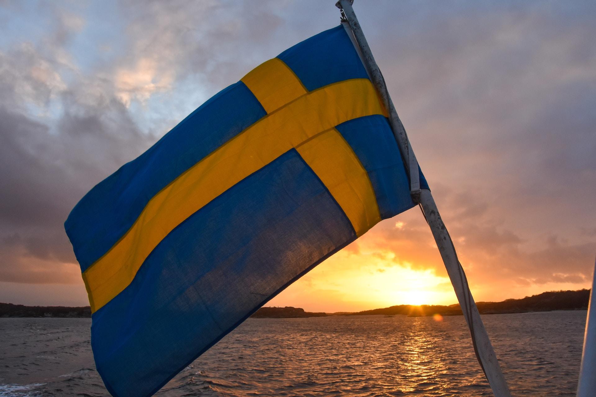 Ruotsin lippu veneessä taustallaan auringonlasku
