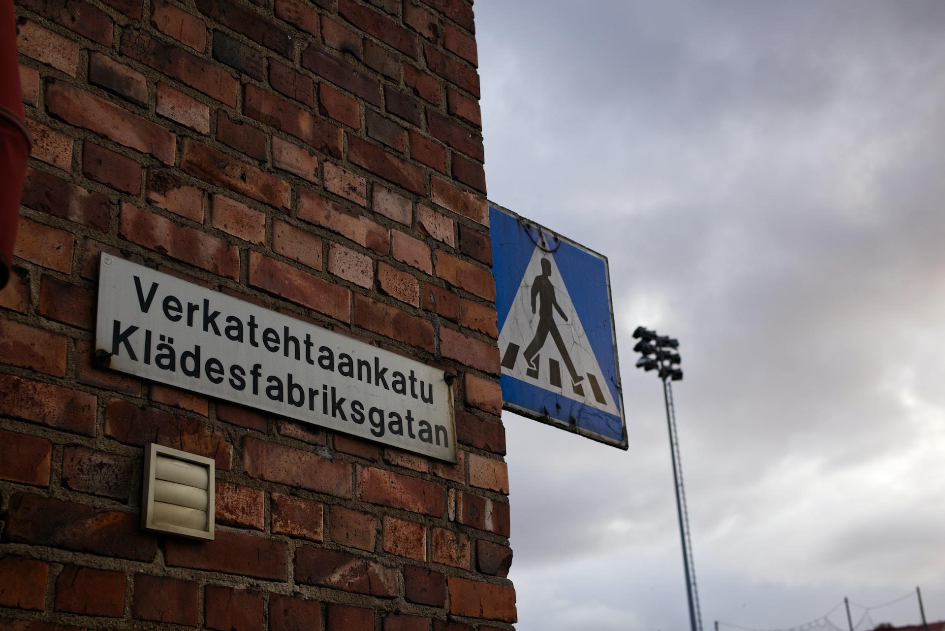 Talon seinässä tienviitta, jossa kadun nimi suomeksi ja ruotsiksi