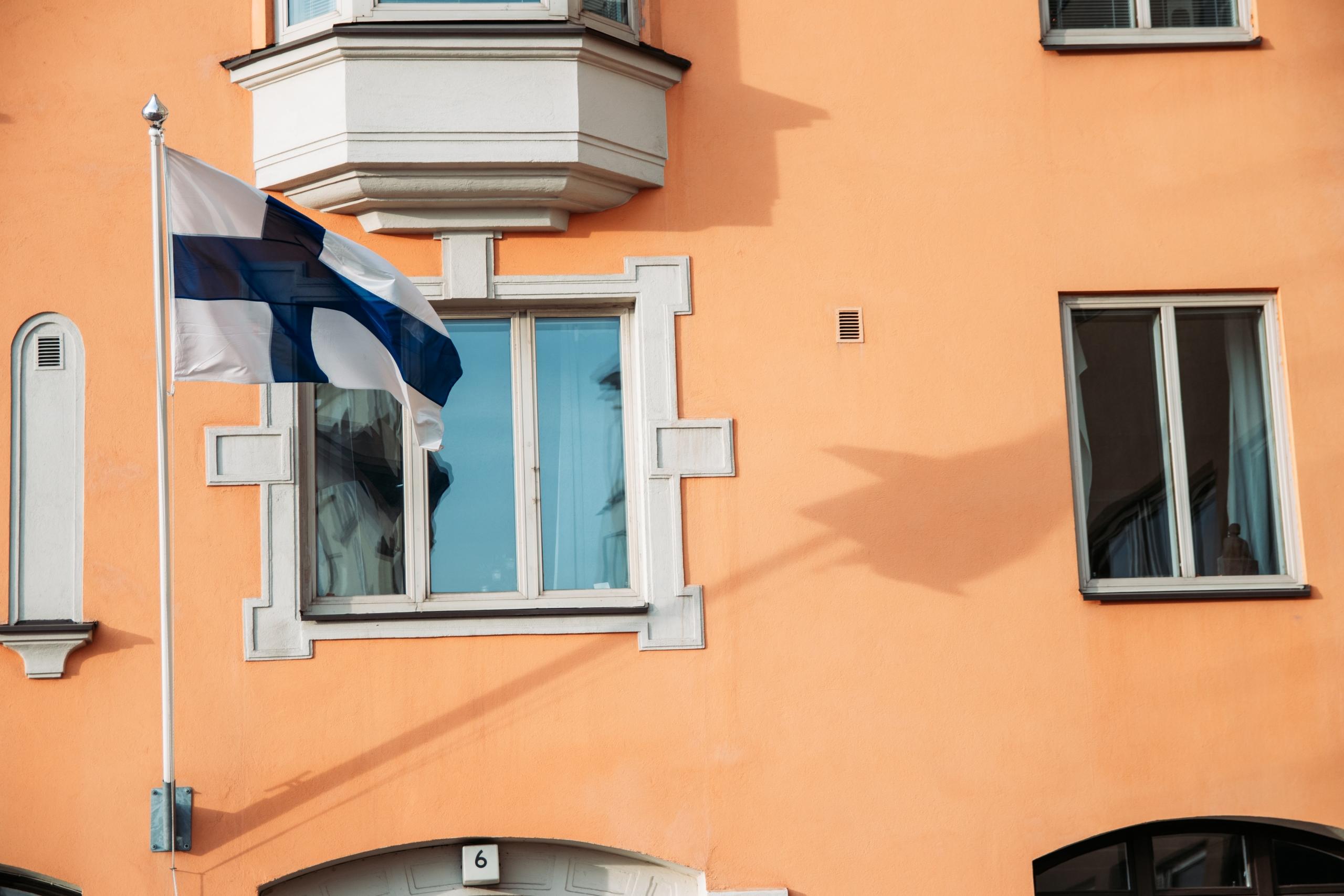 Suomen lippu oranssin kerrostalon seinällä