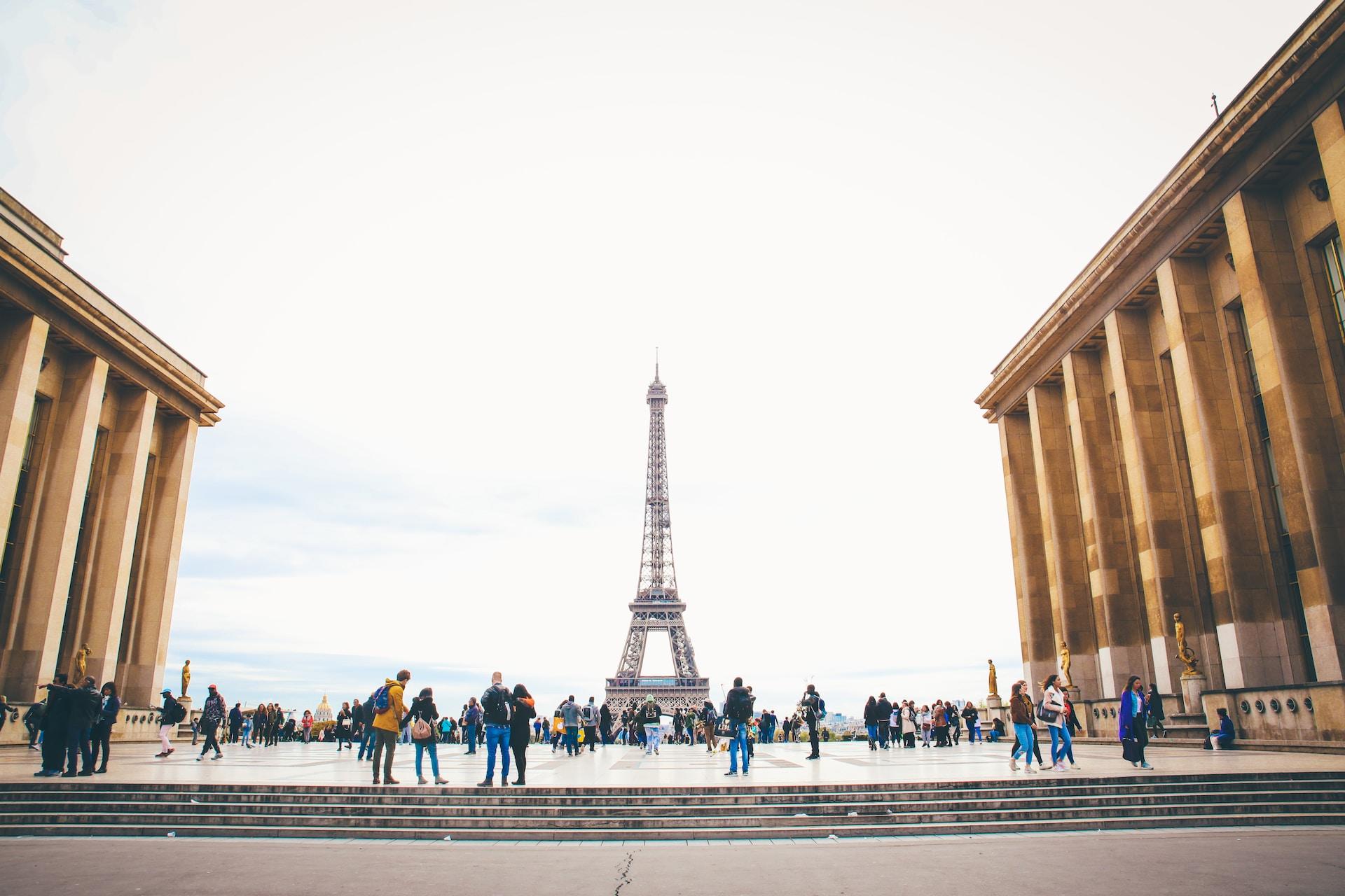 Väkijoukkoa aukiolla Eiffel-tornin häämöttäessä taustalla