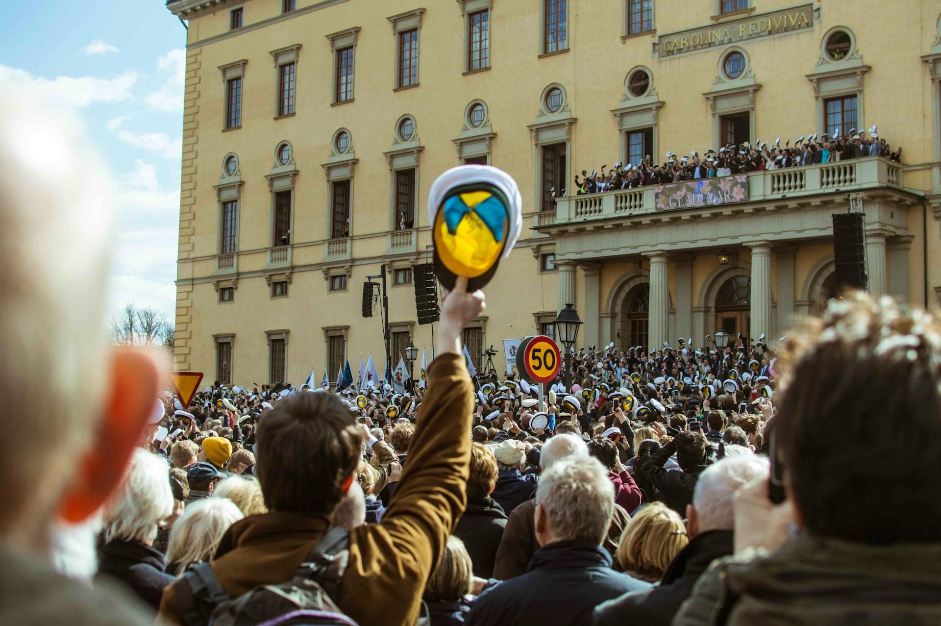 Juhlivia opiskelijoita Uppsalassa valkoisine lakkeineen