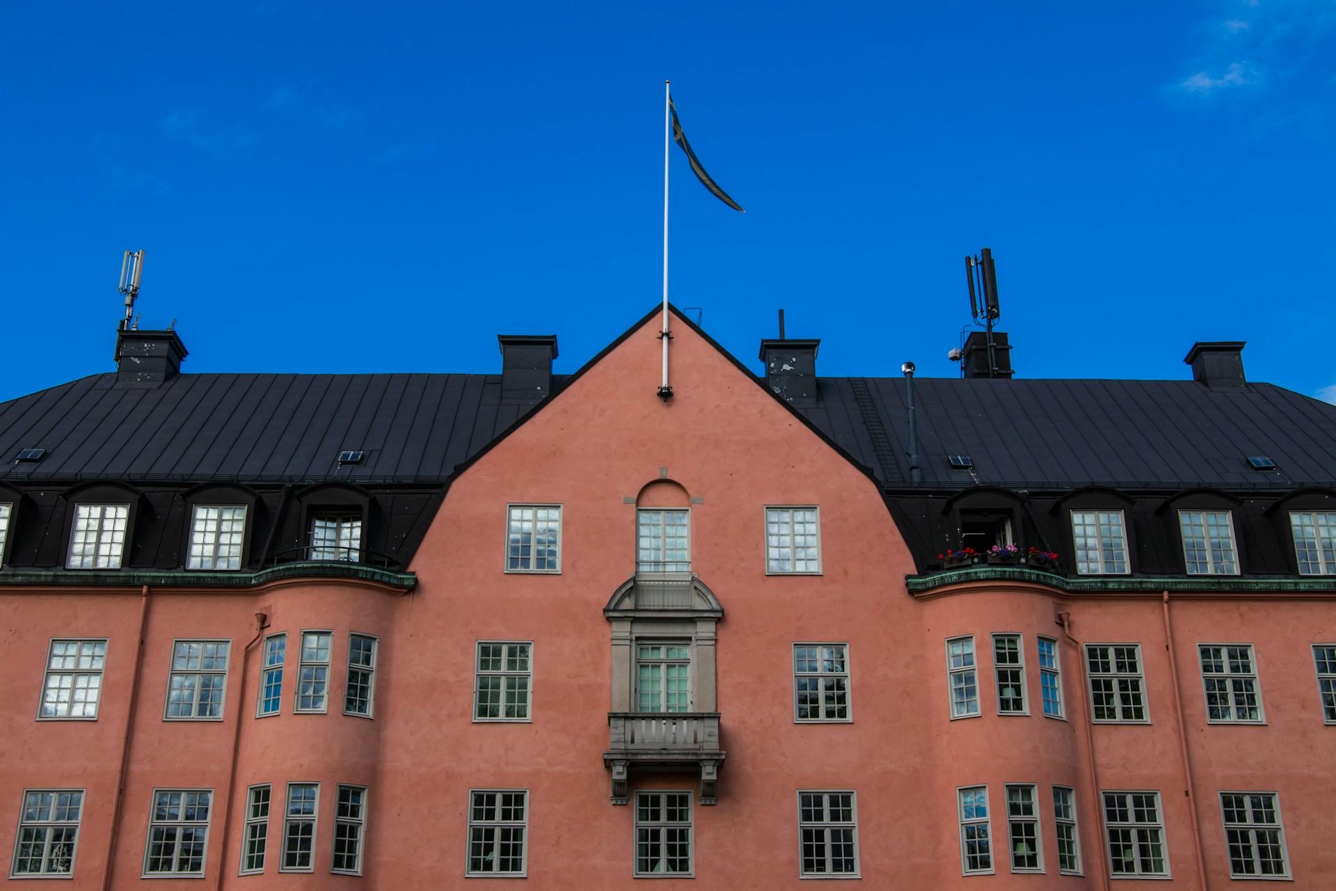 Punainen rakennus, jonka katolla lipputangossa sinikeltainen viiri
