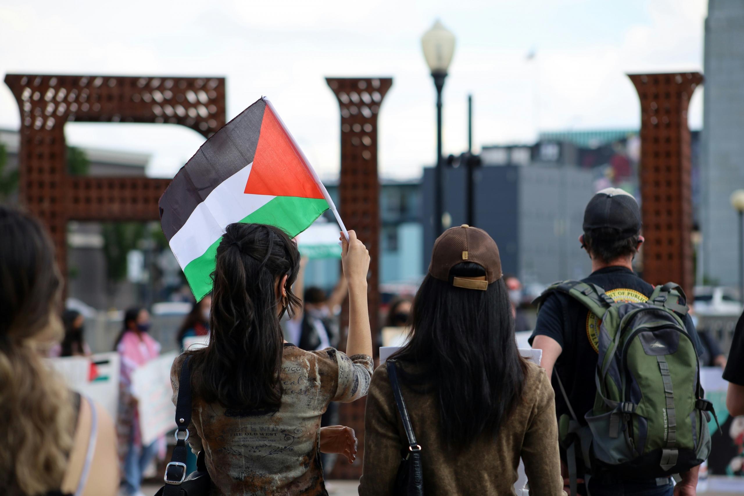 Nuori nainen pitelemässä Palestiinan lippua