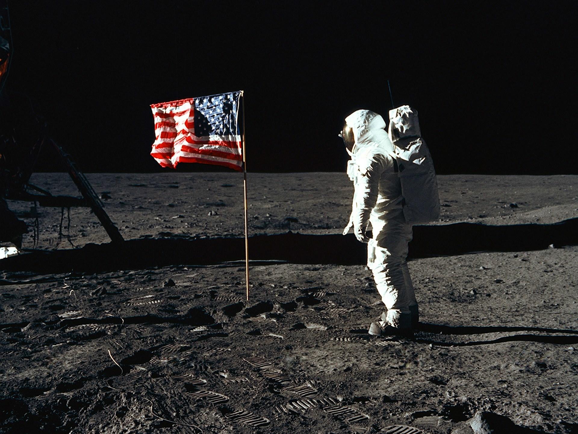 Astronautti ja Amerikan lippu kuun pinnalla