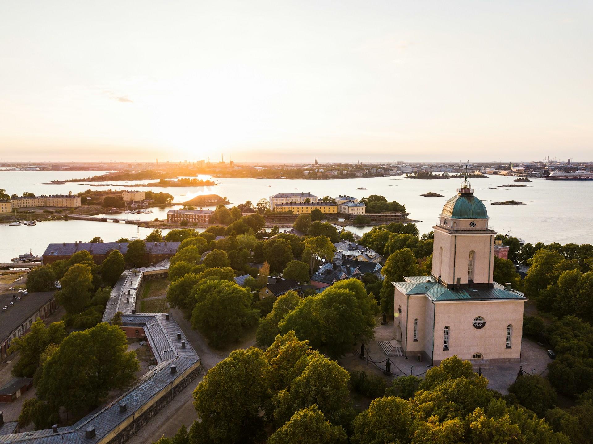 Vaalea linna saaressa puiden ympäröimänä