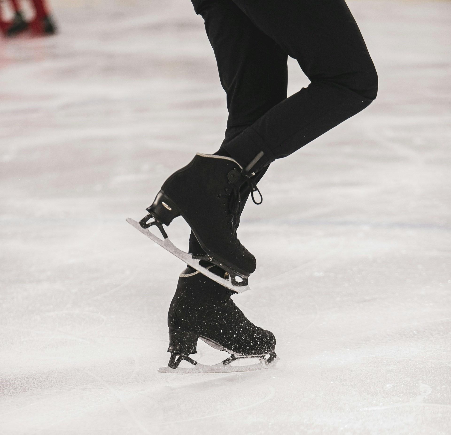 Henkilö luistelemassa mustissa taitoluistimissa