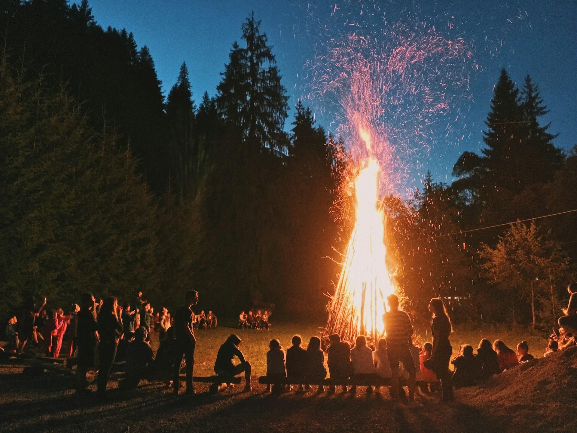 Ihmisiä istumassa kokon ympärillä