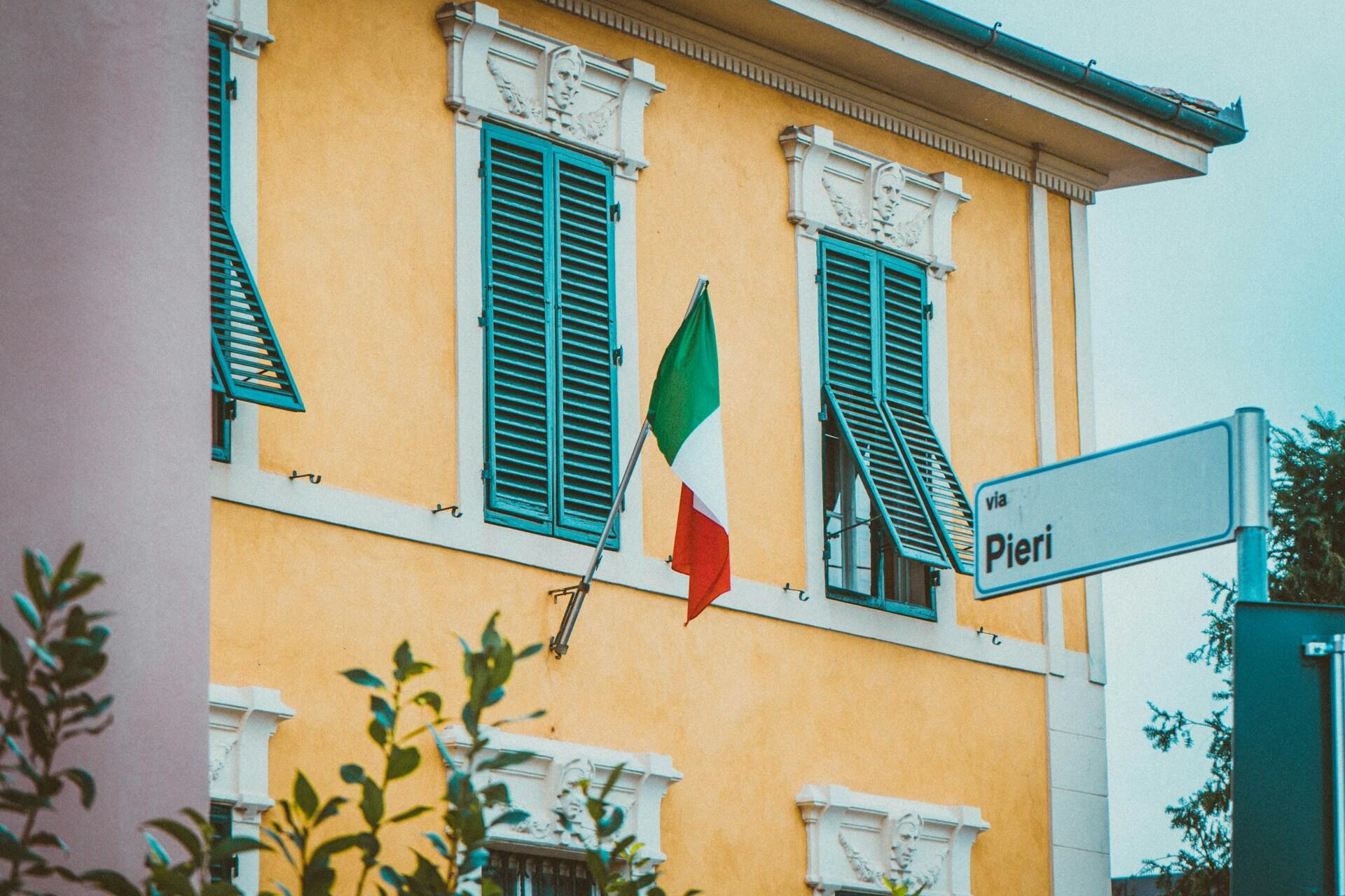 Italian lippu keltaisen talon seinässä