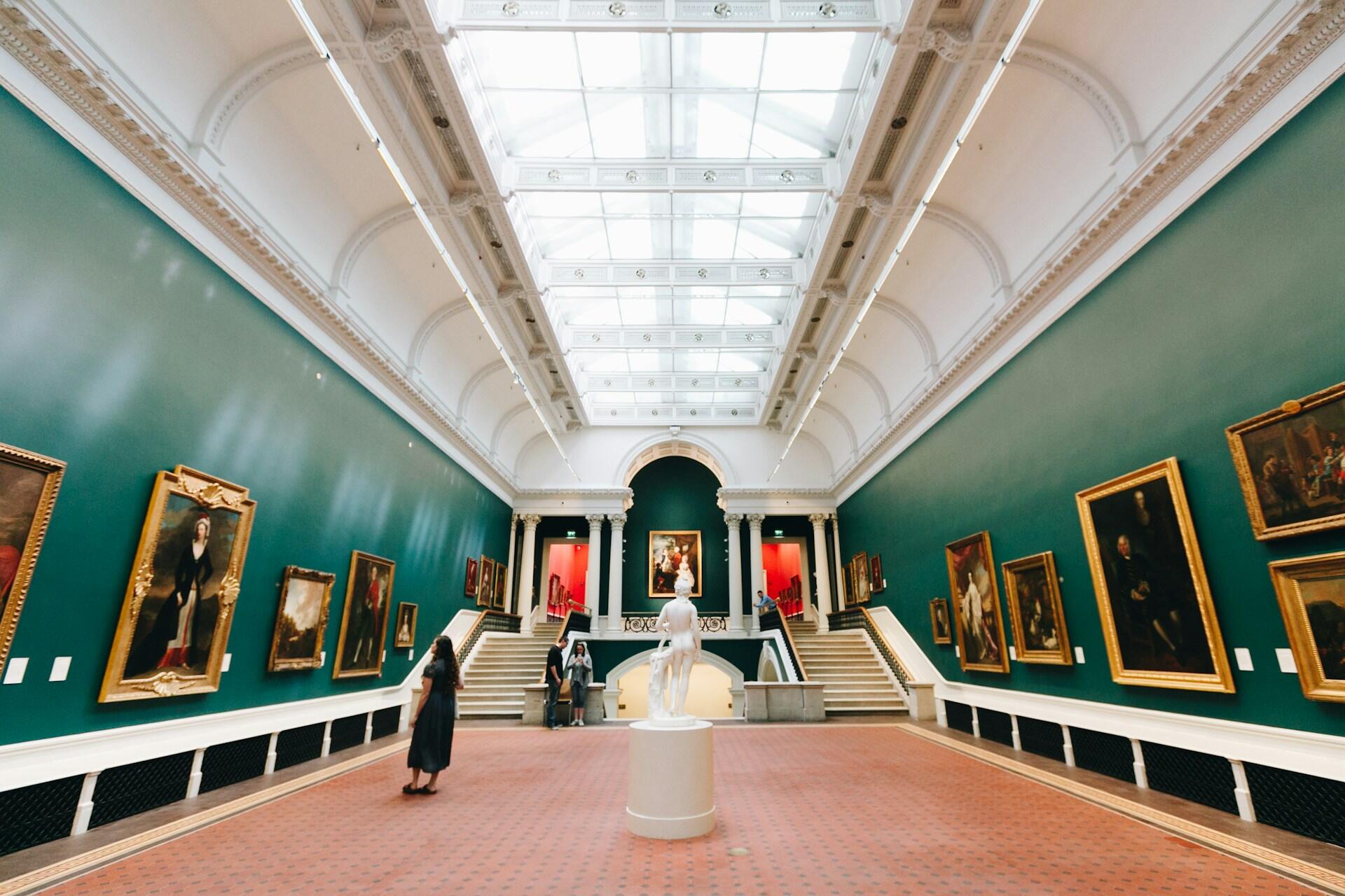 Nainen katsomassa tauluja museossa