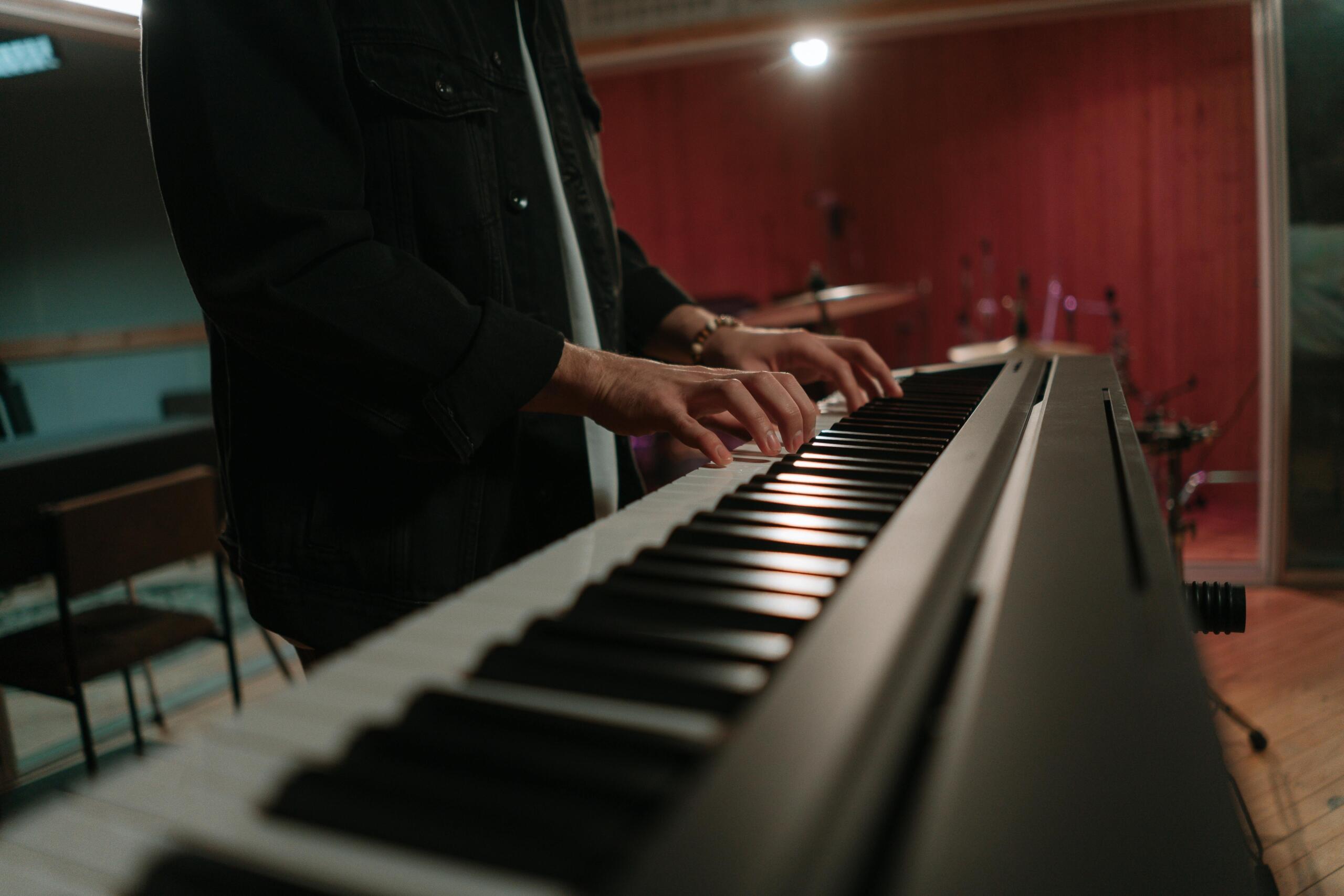 Henkilö soittamassa sähköpianoa seisten