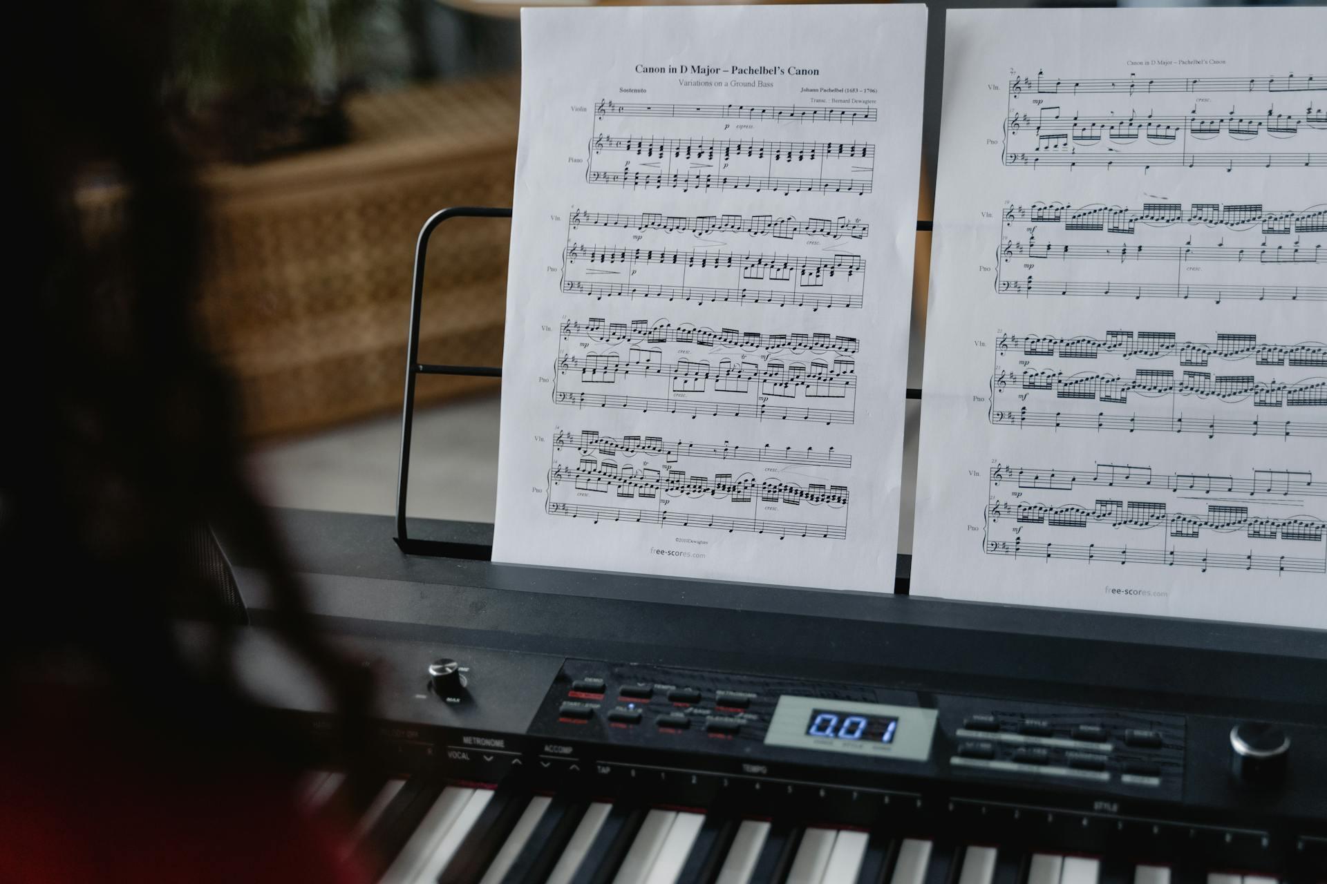 Henkilö soittamassa pianoa nuoteista