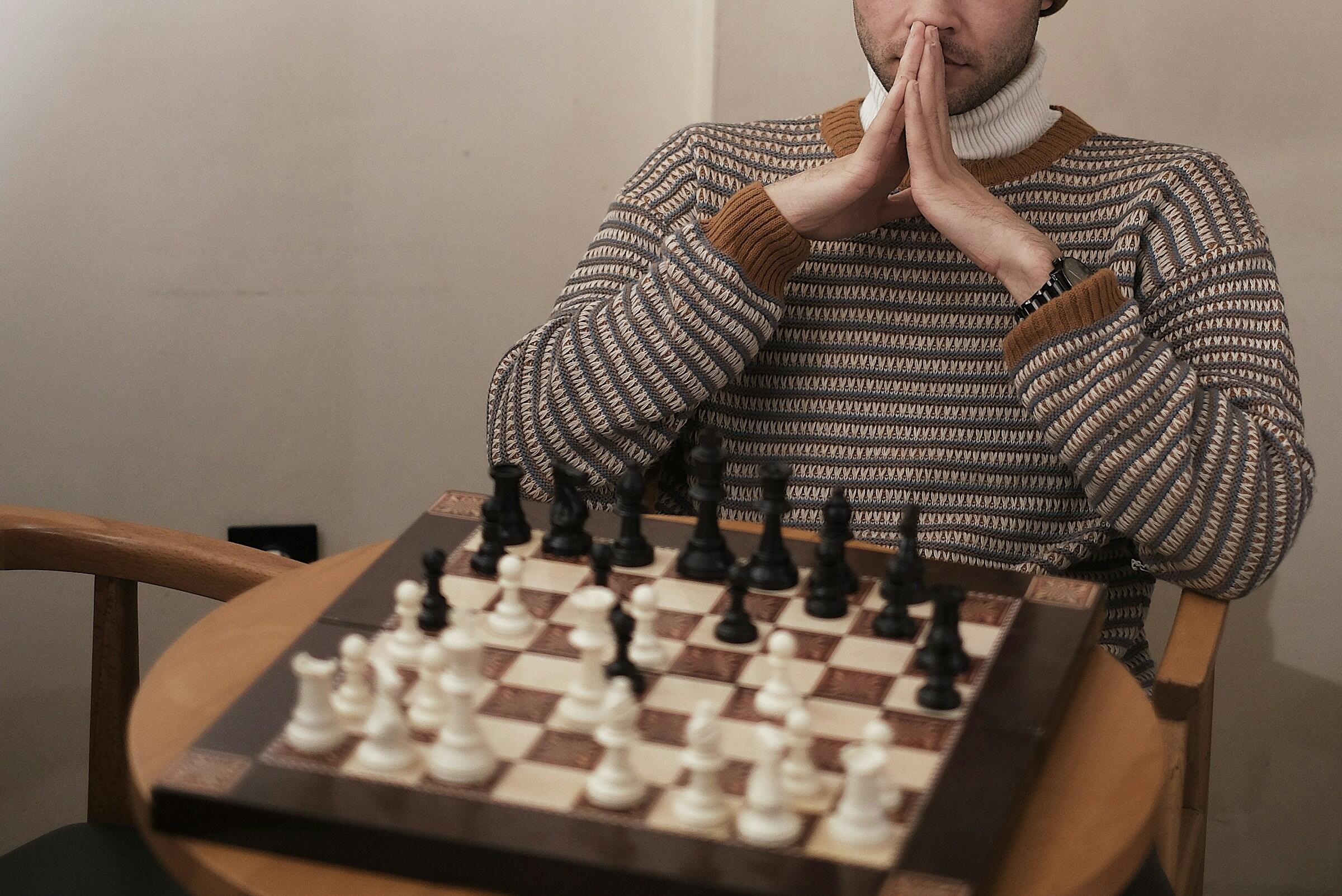 Ihminen miettimässä seuraavaa shakkisiirtoa