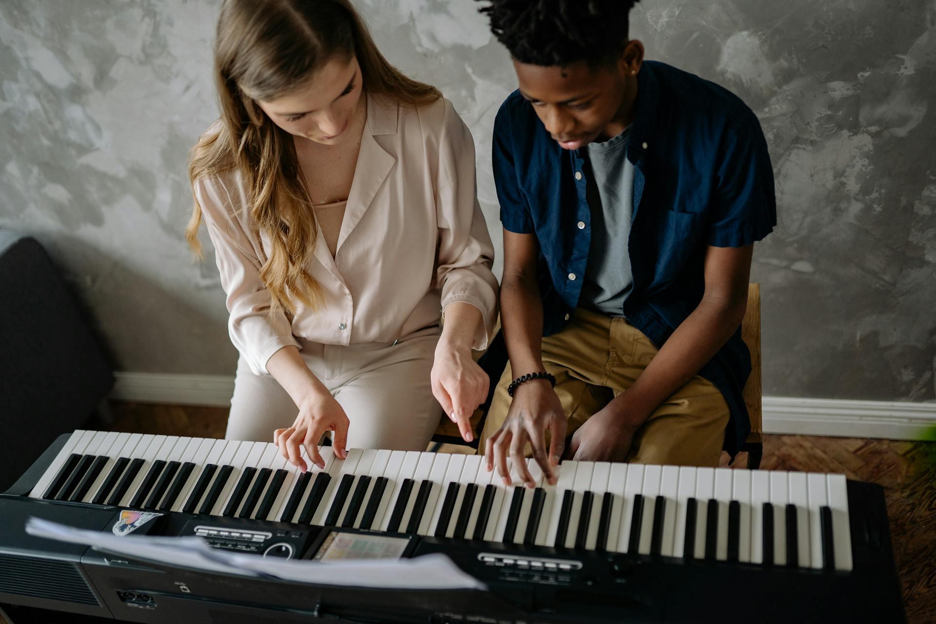 Mies ja nainen soittamassa pianoa