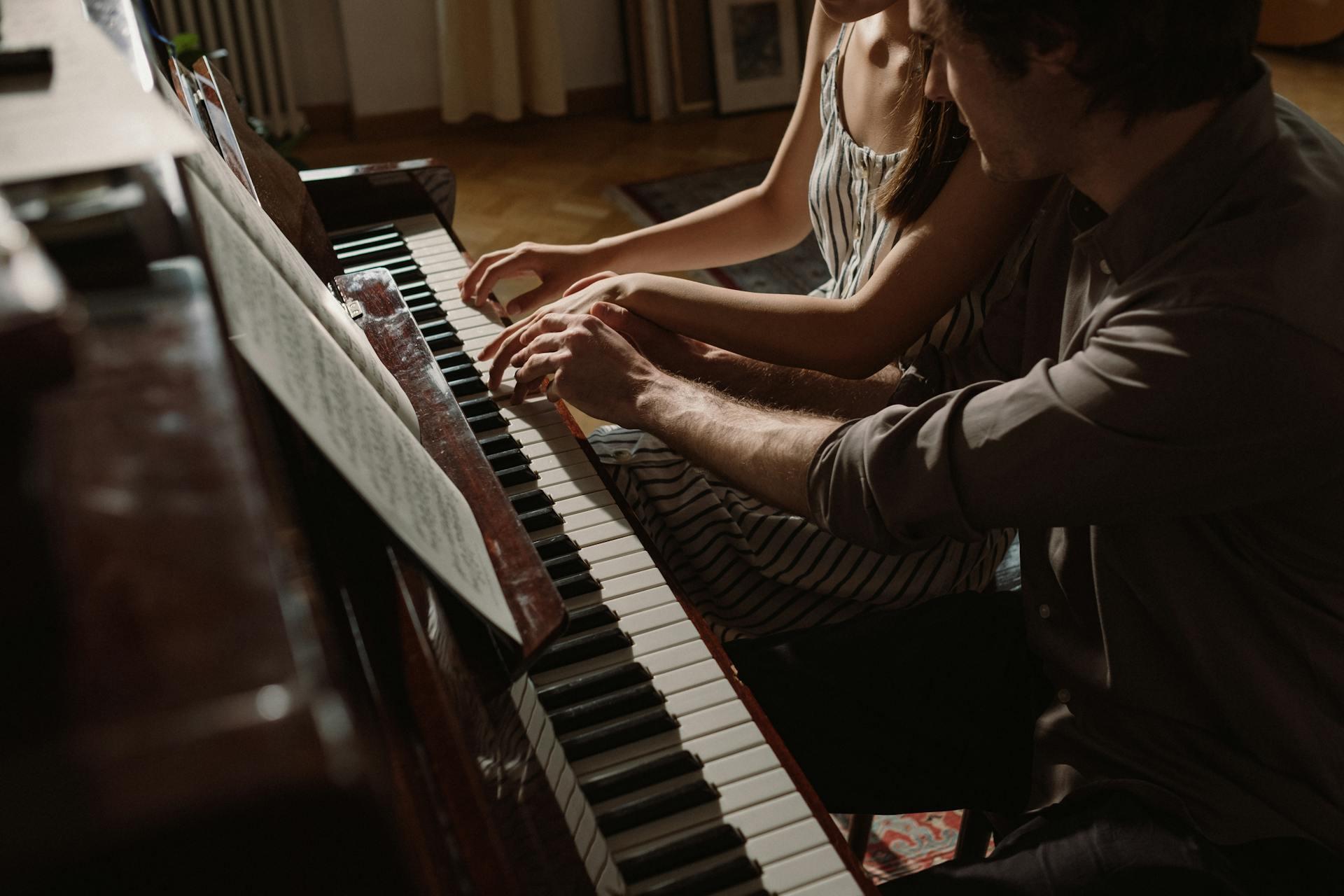Mies ja nainen soittamassa pianoa