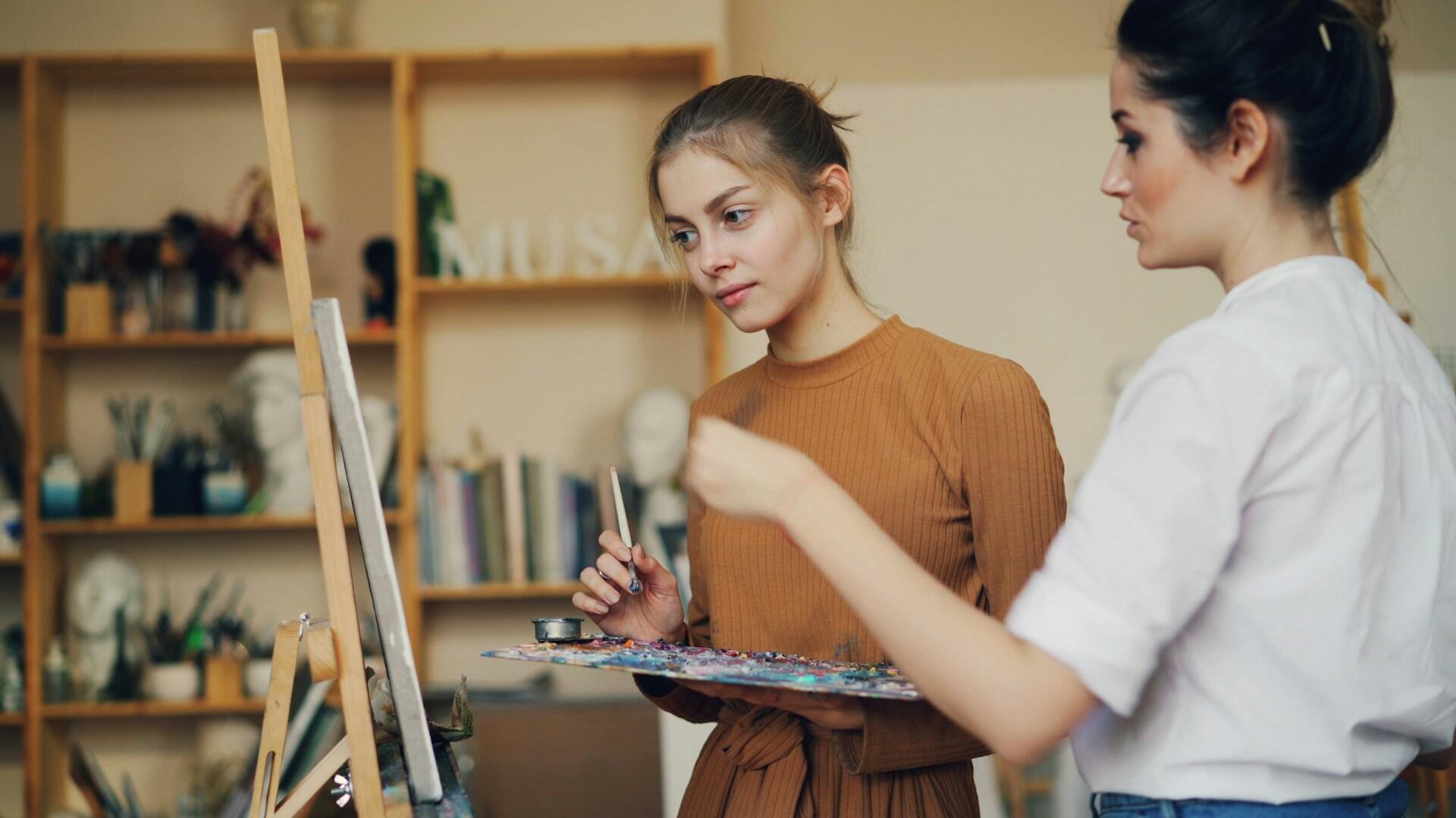 Kaksi naista maalaamassa taulua