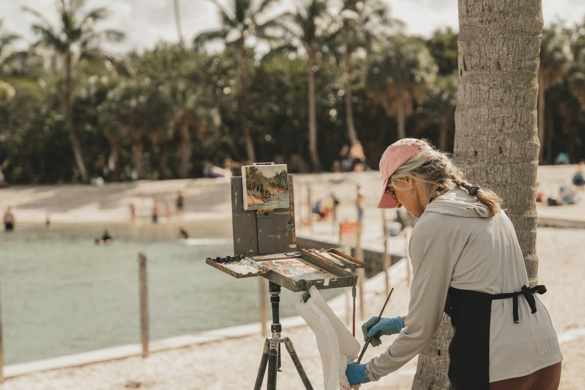 Nainen maalaamassa hiekkarantaa