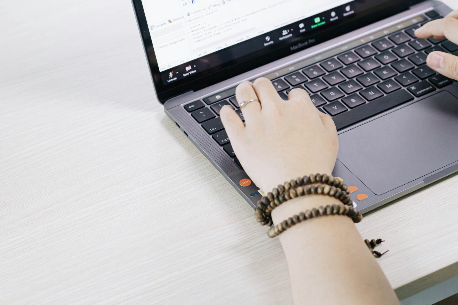 Kädet kannettavan tietokoneen näppäimistöllä