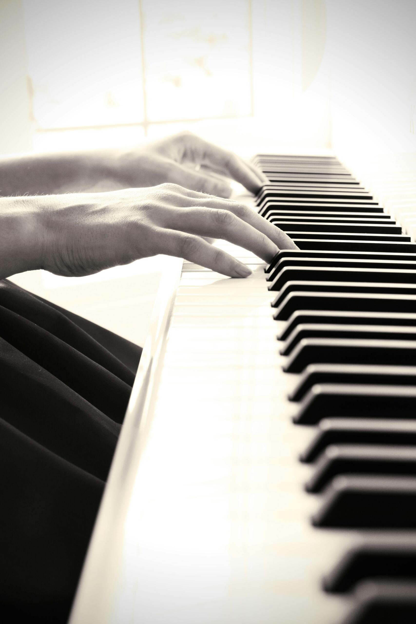 Kädet pianon koskettimilla
