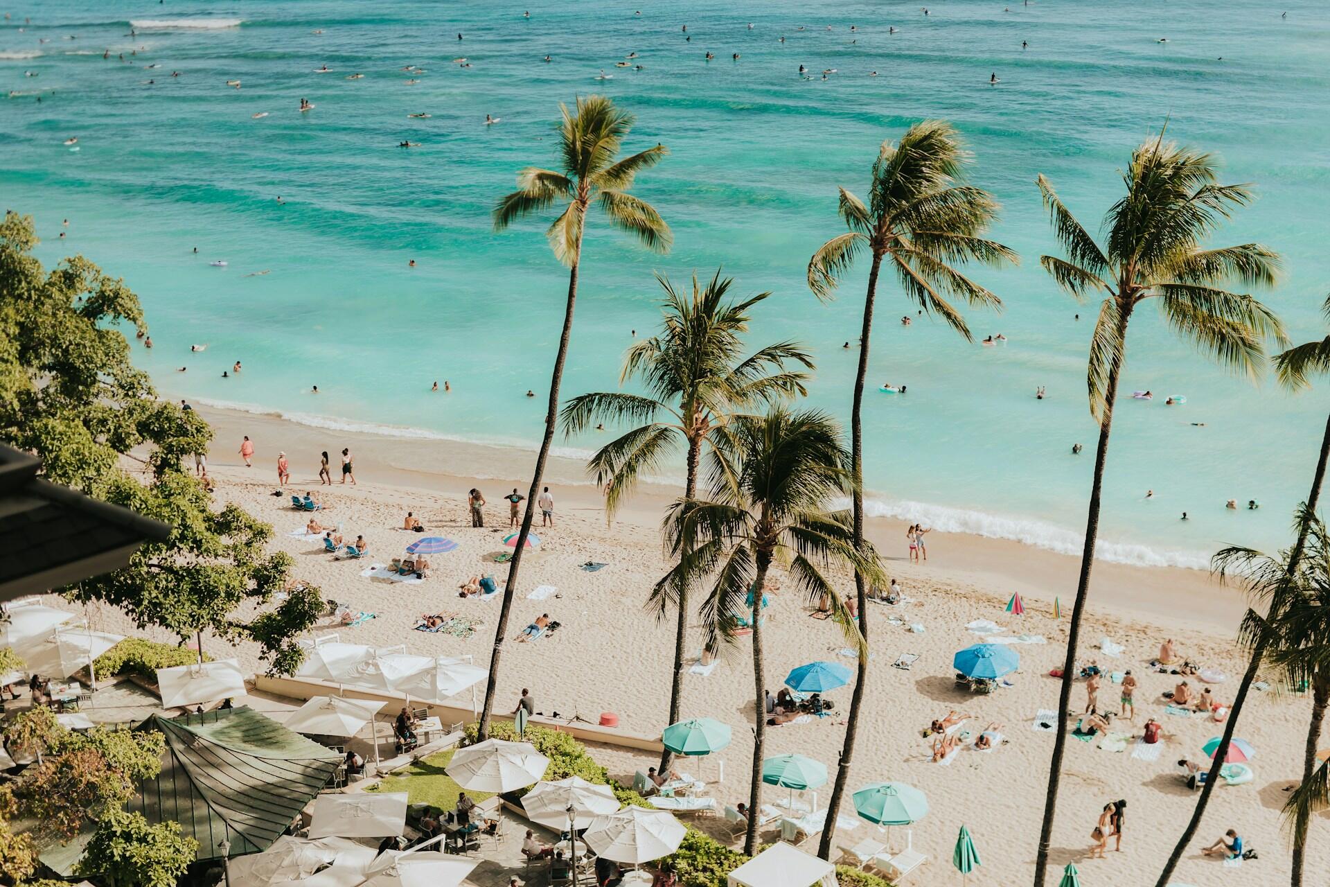 Ihmisiä ottamassa aurinkoa hiekkarannalla