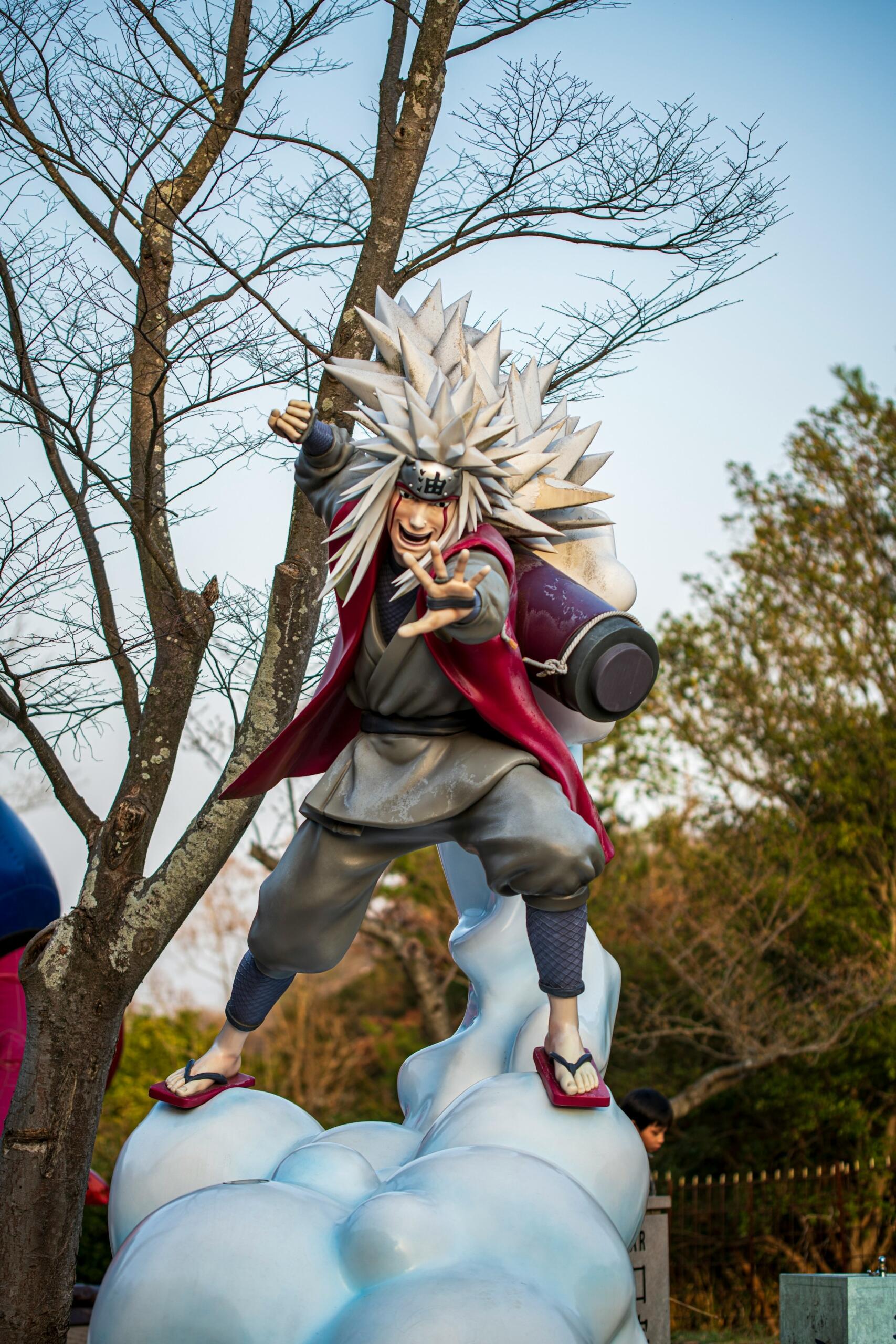 Valkohiuksinen animehahmo tosielämän koossa puistossa