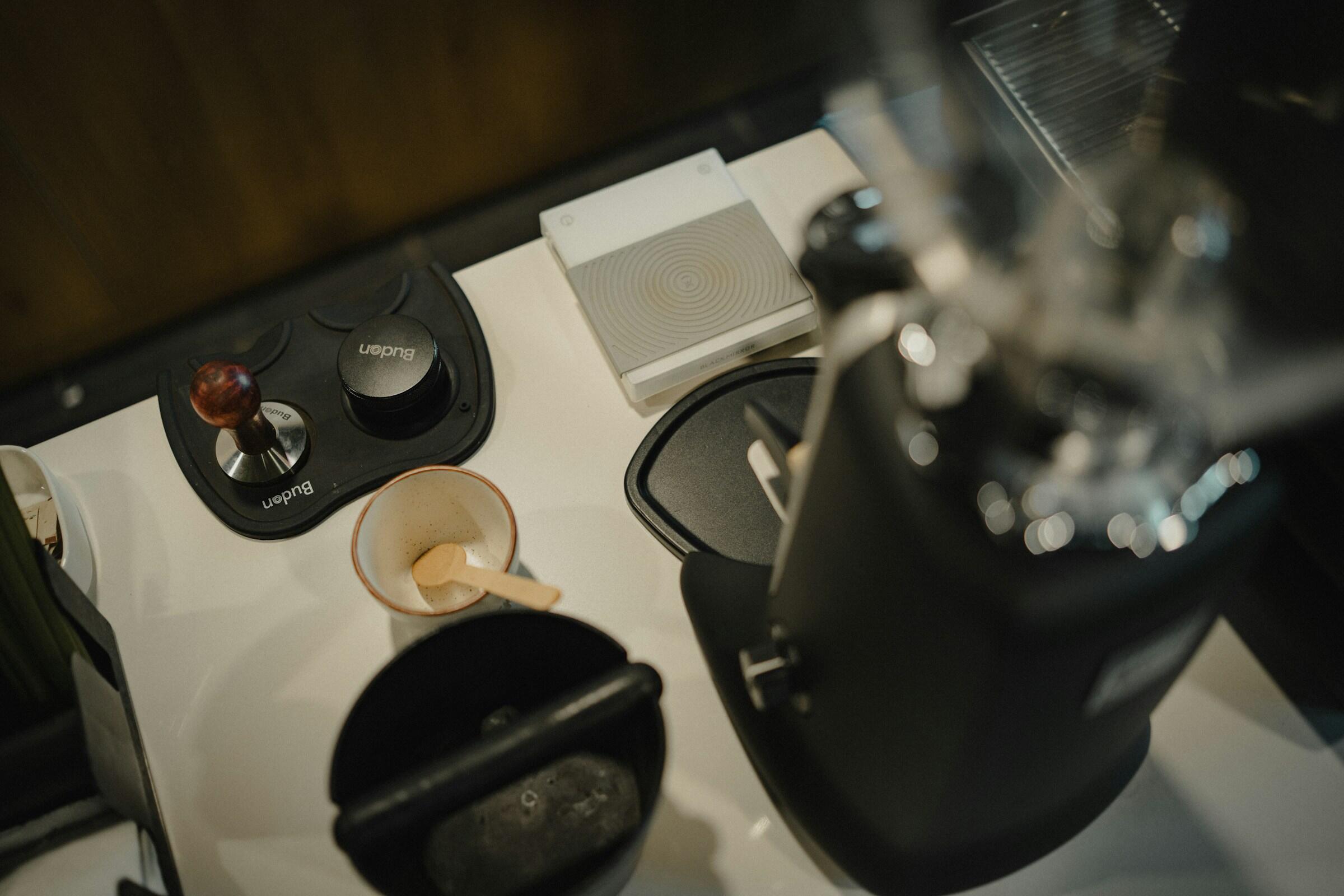 Erilaisia kahvitarvikkeita ja -välineitä keittiötasolla