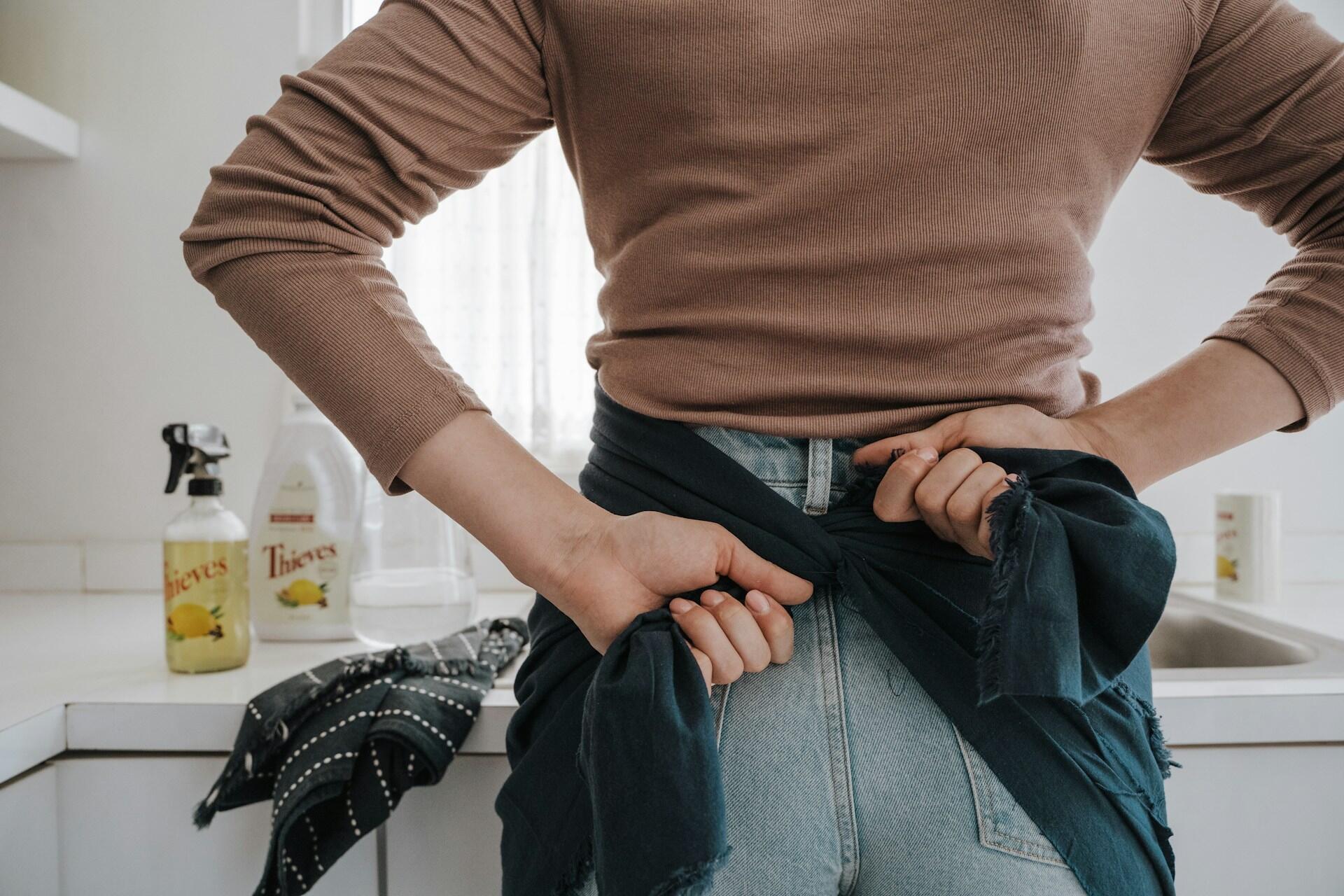 Nainen laittamassa essua päälle