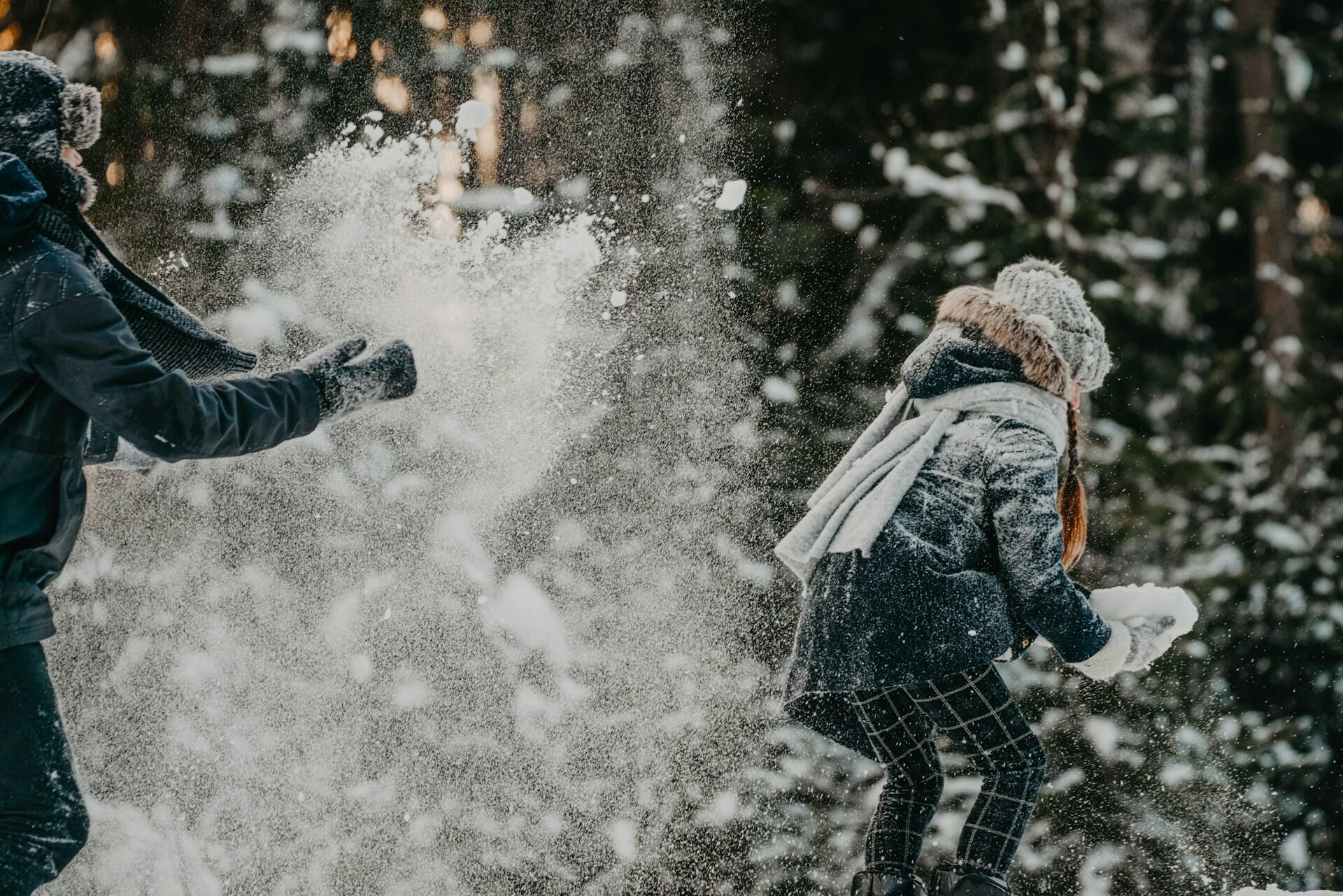 Lapset leikkimässä lumisotaa