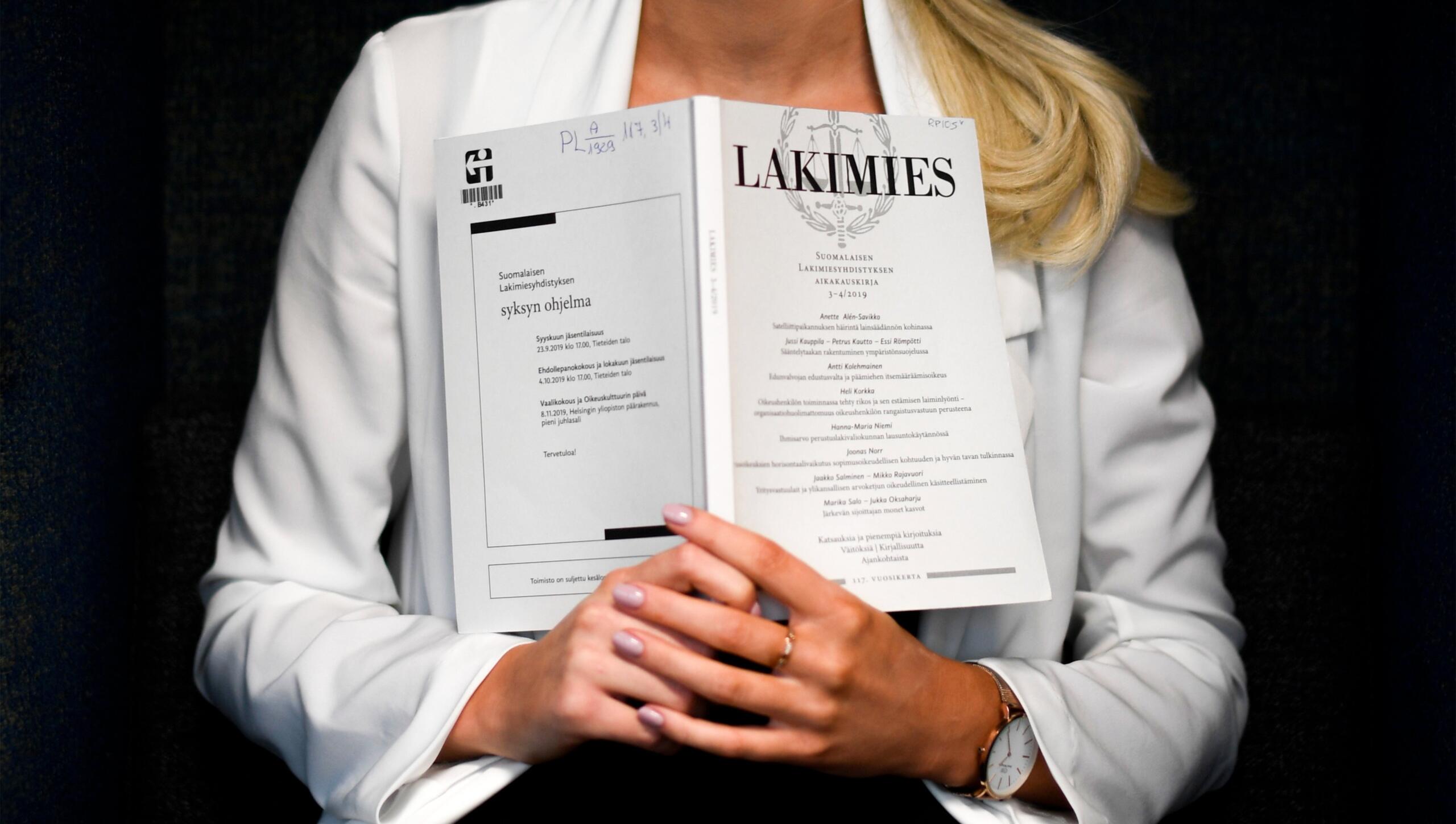 Lakimies-niminen kirja naisen kädessä