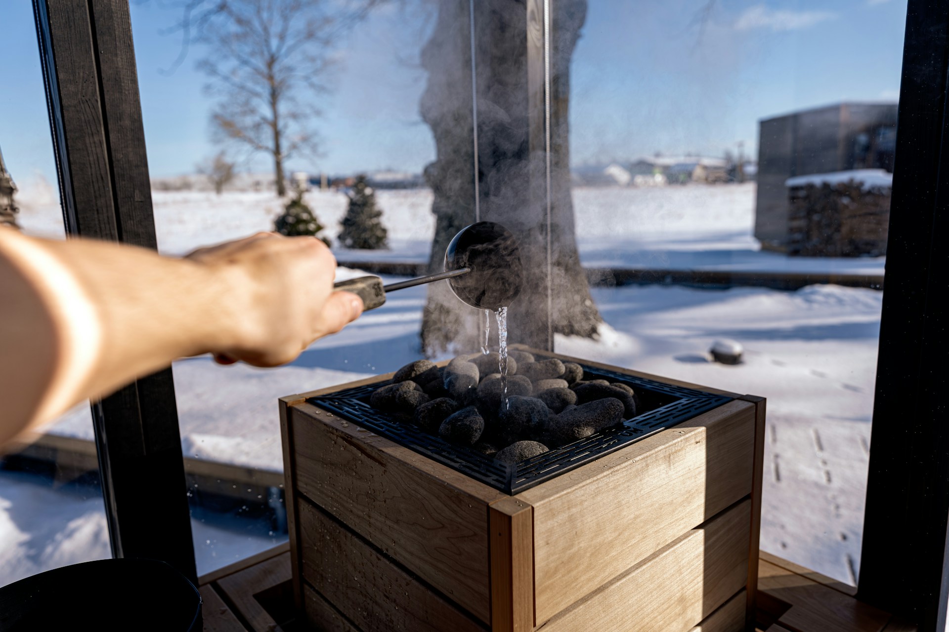 Mies heittämässä kiukaalle vettä