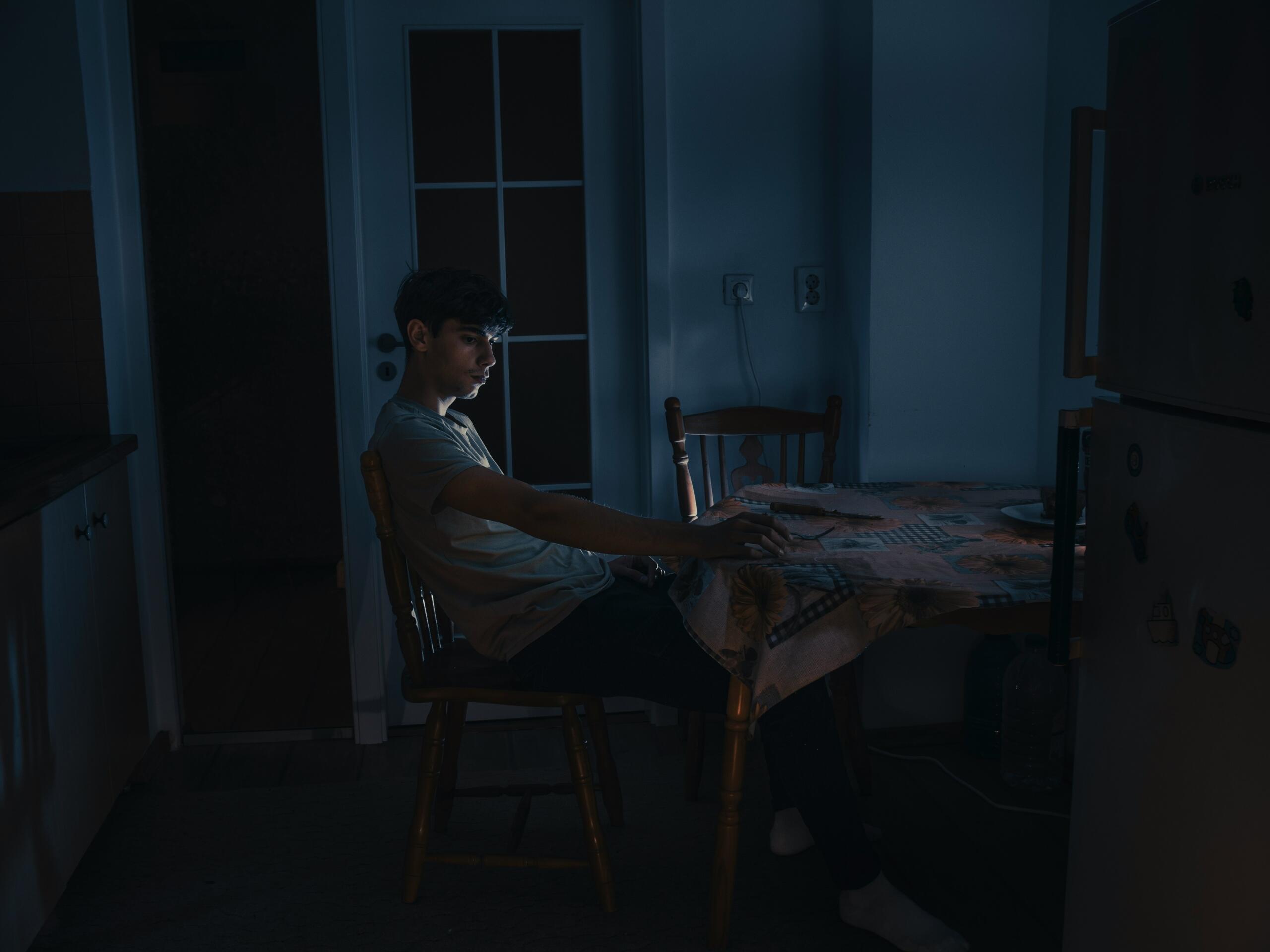 Tiener zit alleen in een donkere kamer met licht van een computerscherm op zijn gezicht David Caus, via Unsplash