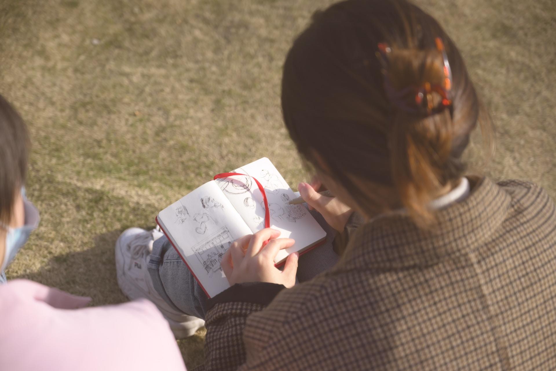 Vrouw tekent in notitie blok