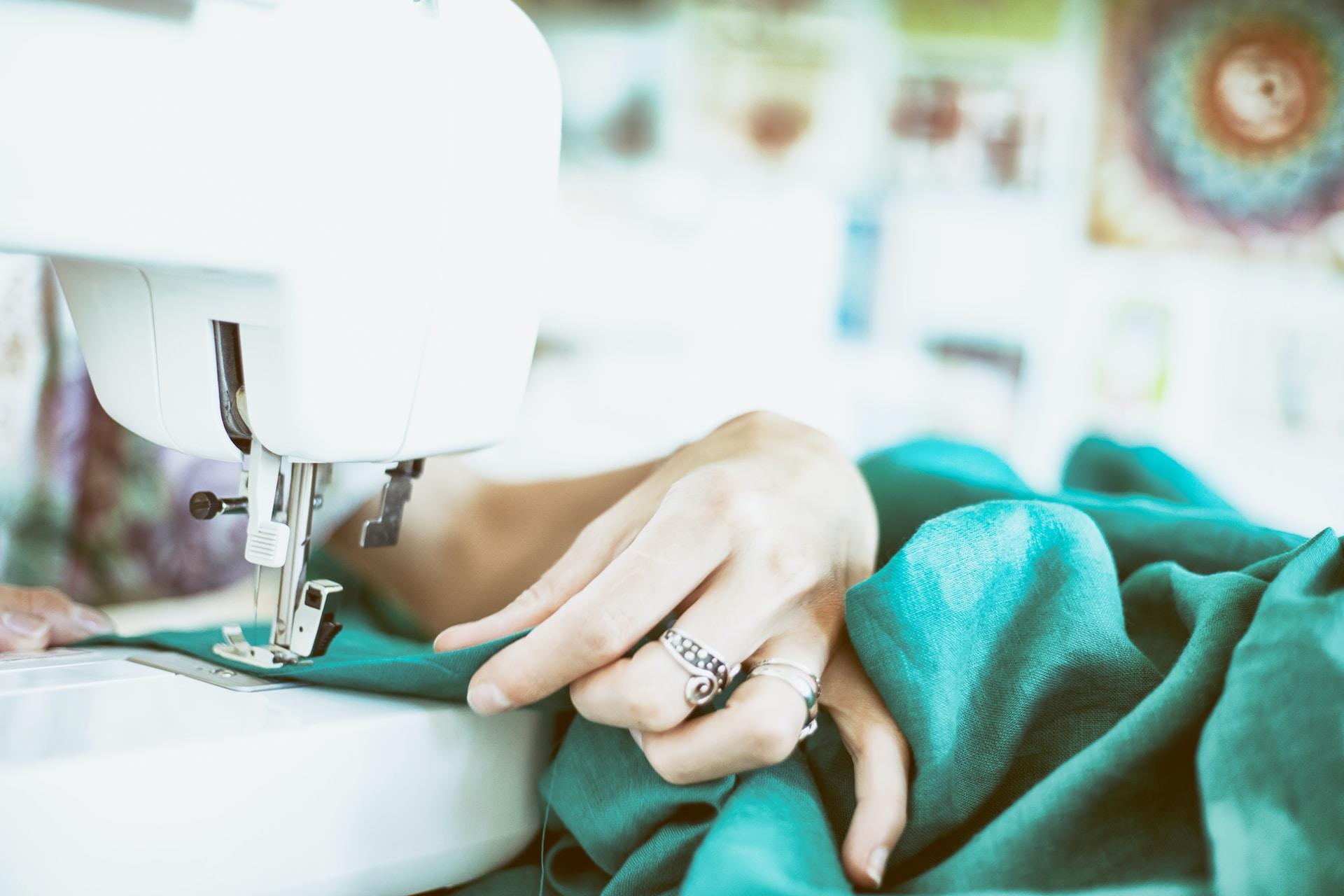 Persoon maakt kleding met naaimachine